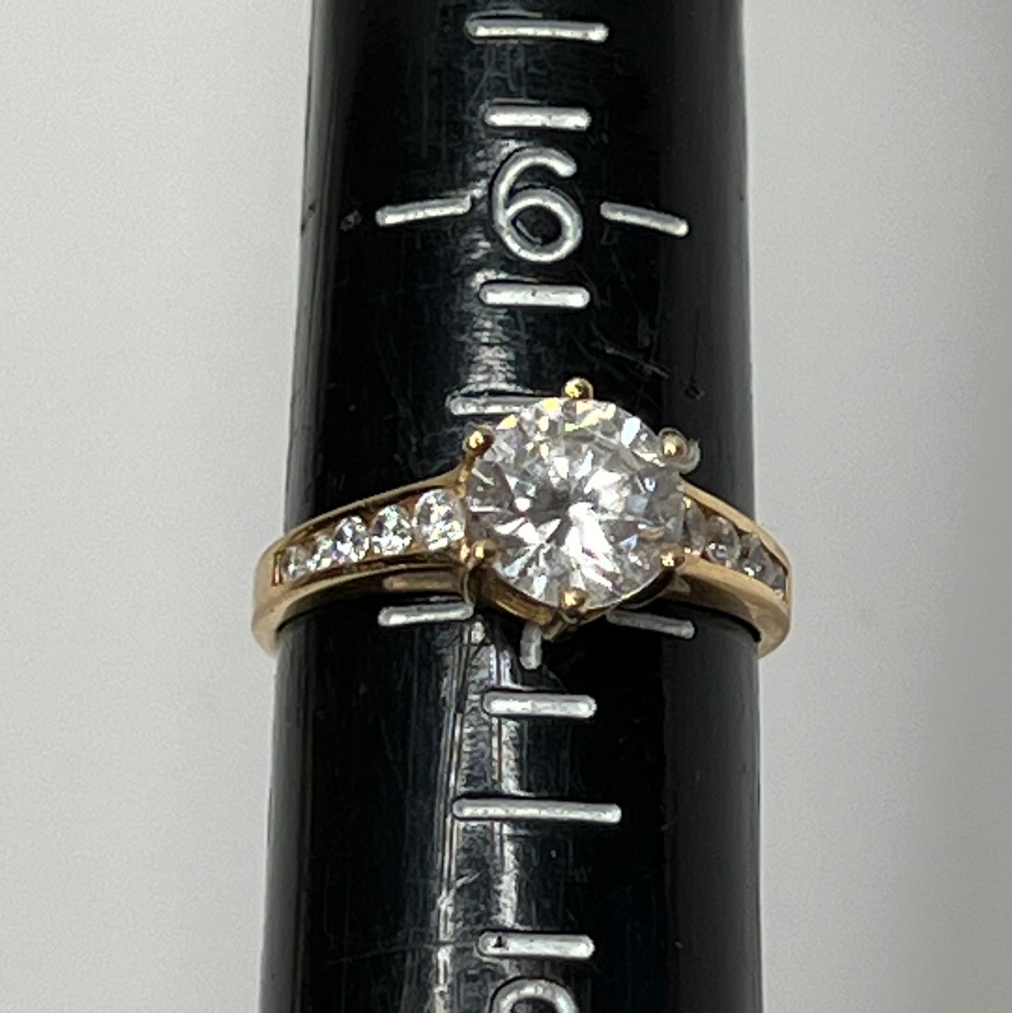 Vintage 10K gold CZ solitaire ring on hand with channel-set accents