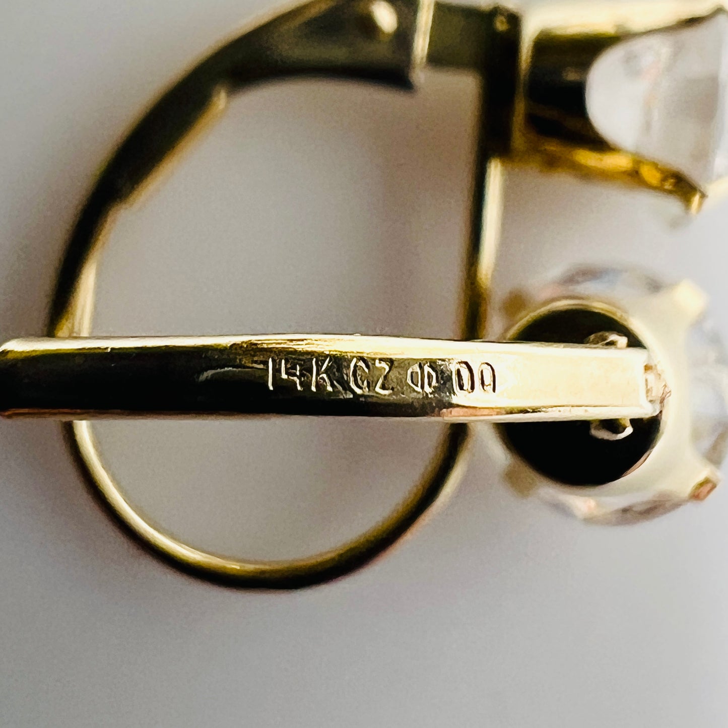 Close-up of earring stamp reading “14K CZ” and Diamonique logo