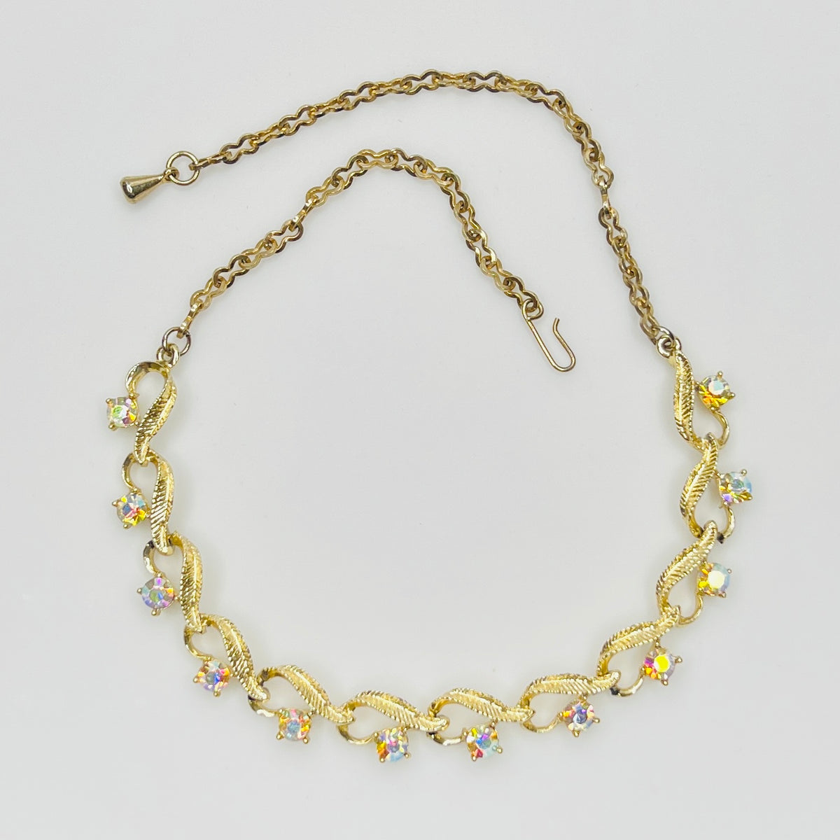 Flat lay of vintage aurora borealis choker with twisted gold links