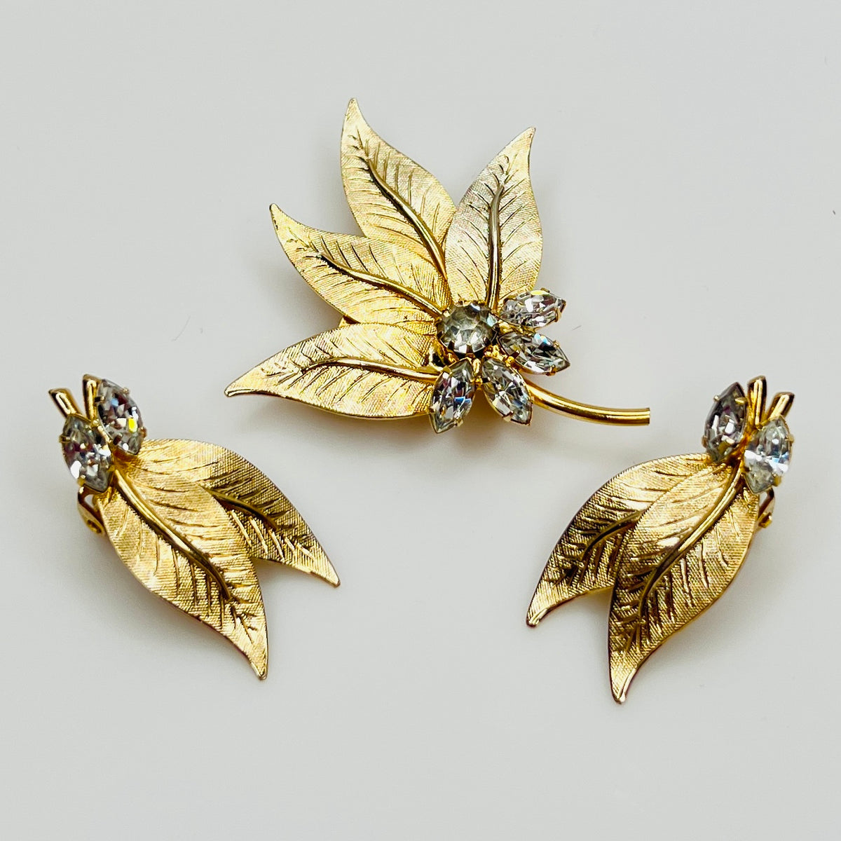 1950s gold-tone brooch and matching clip-on earrings with rhinestone accents