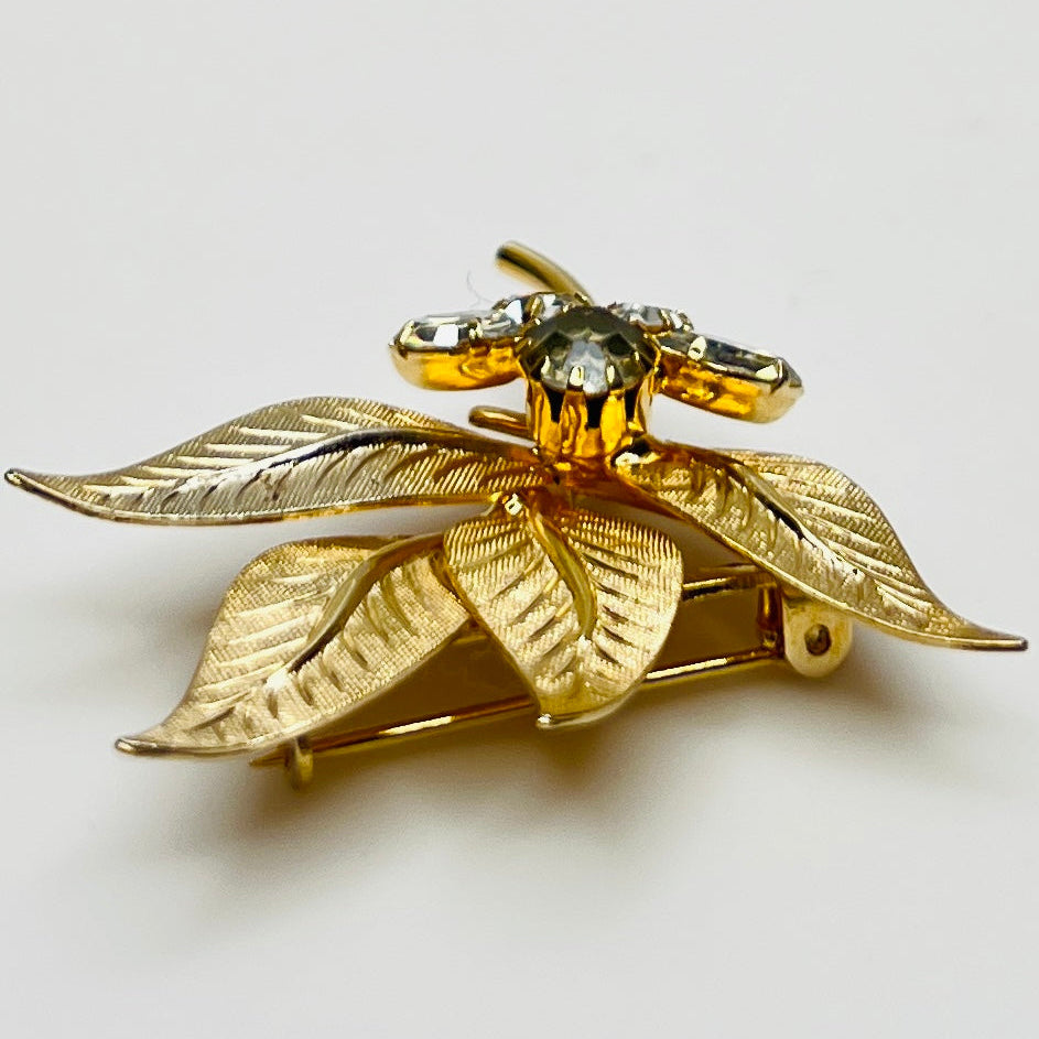 Close-up of gold-tone leaf brooch with clear rhinestones