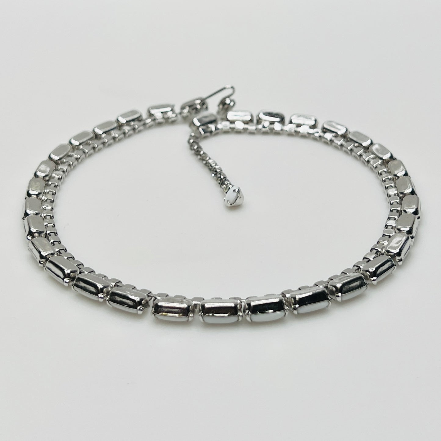 1950s milk glass and rhinestone choker necklace with silver-tone setting and hook closure.