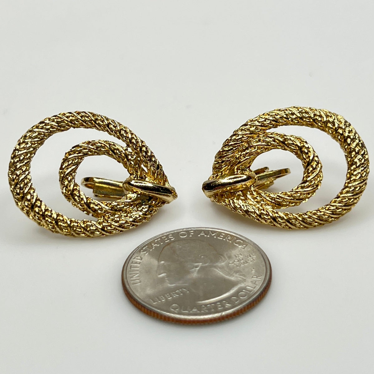 Clip-on earrings with quarter for scale, twisted double-loop design