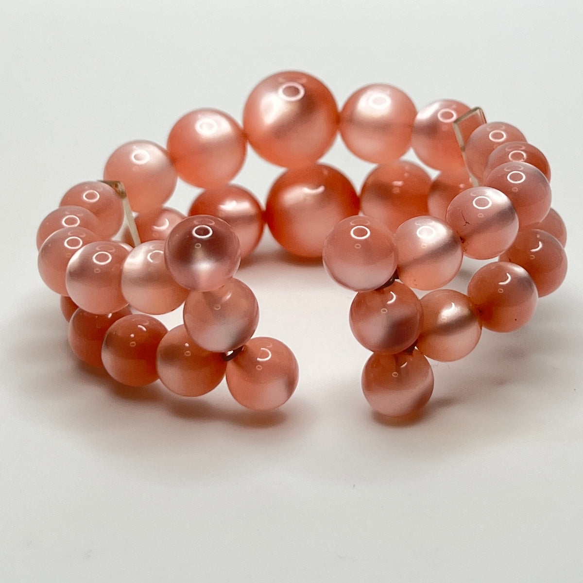 Vintage pink lucite cuff bracelet in open wire design, glowing bead detail