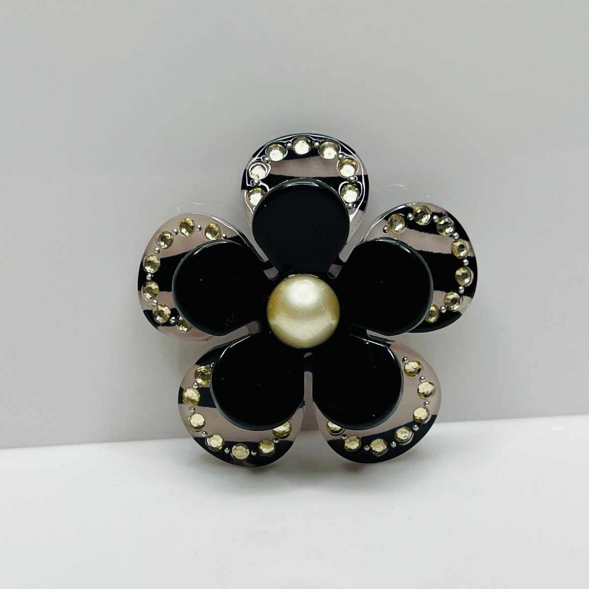 1970s black Lucite flower brooch with rhinestones and pearl center