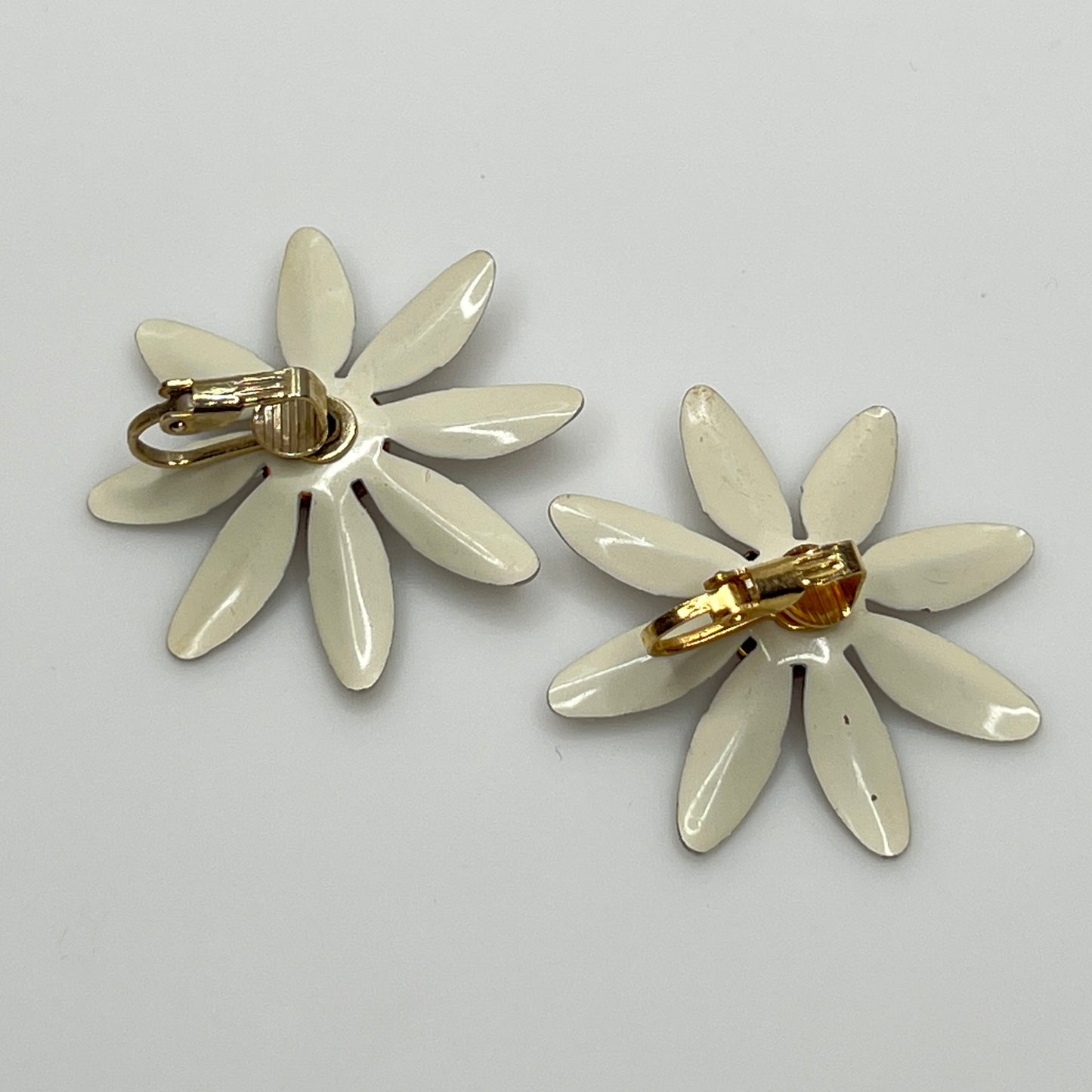 Clip-on enamel daisy earrings with white petals and brown centers