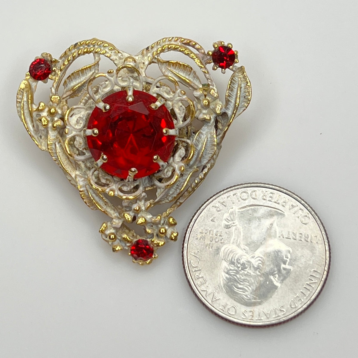 Ruby red vintage brooch with quarter shown for scale