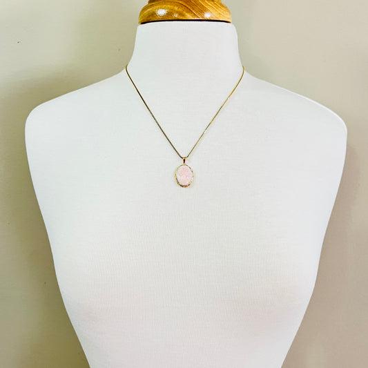 Cameo pendant necklace displayed on mannequin with gold chain