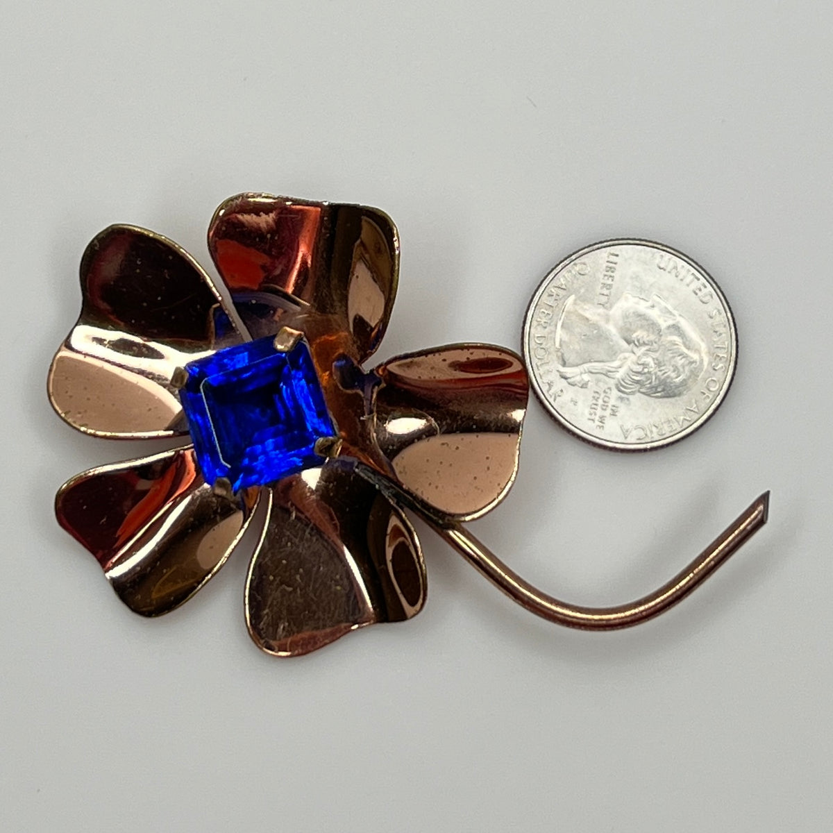 Vintage brooch with quarter for scale showing size and shape