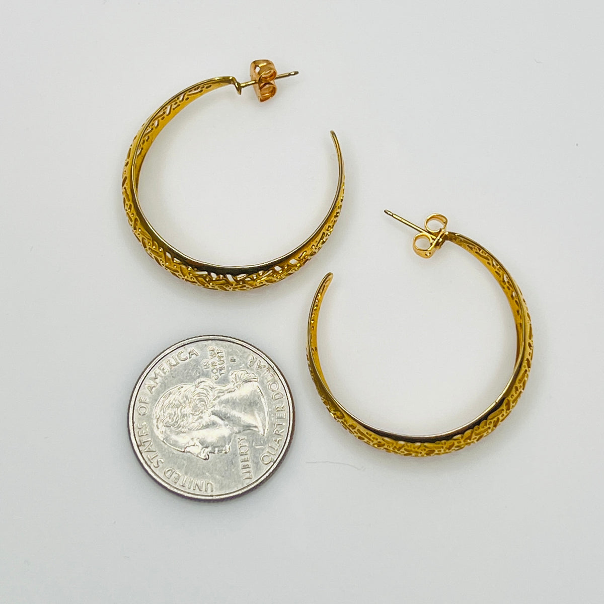Domed gold-tone hoops with intricate lattice design, side view