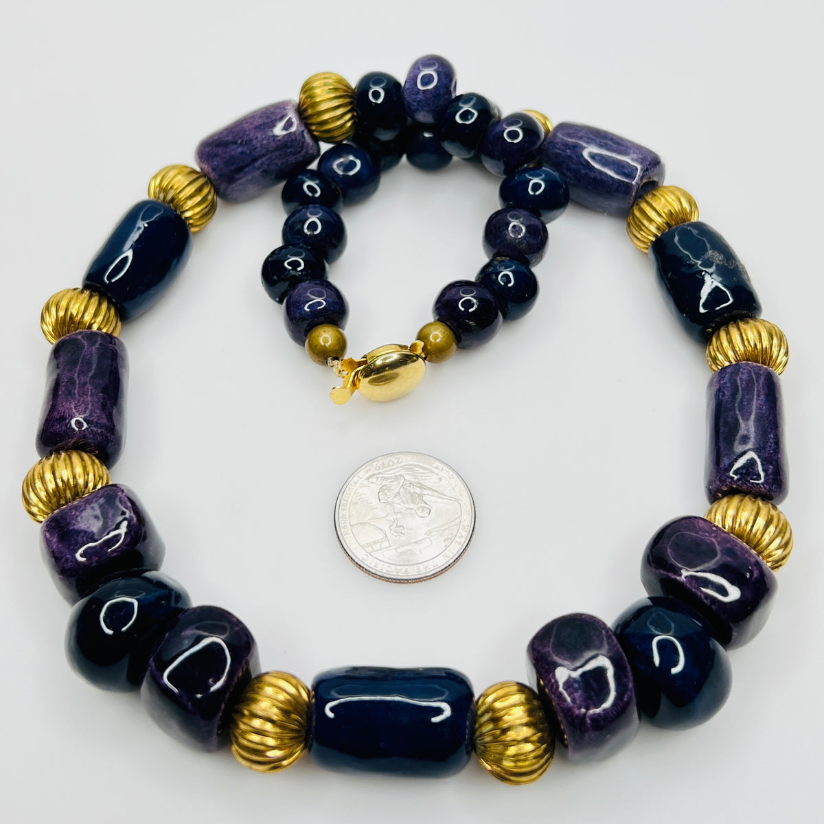 Close-up of gold tone box clasp and glossy ceramic beads, 21 inch necklace