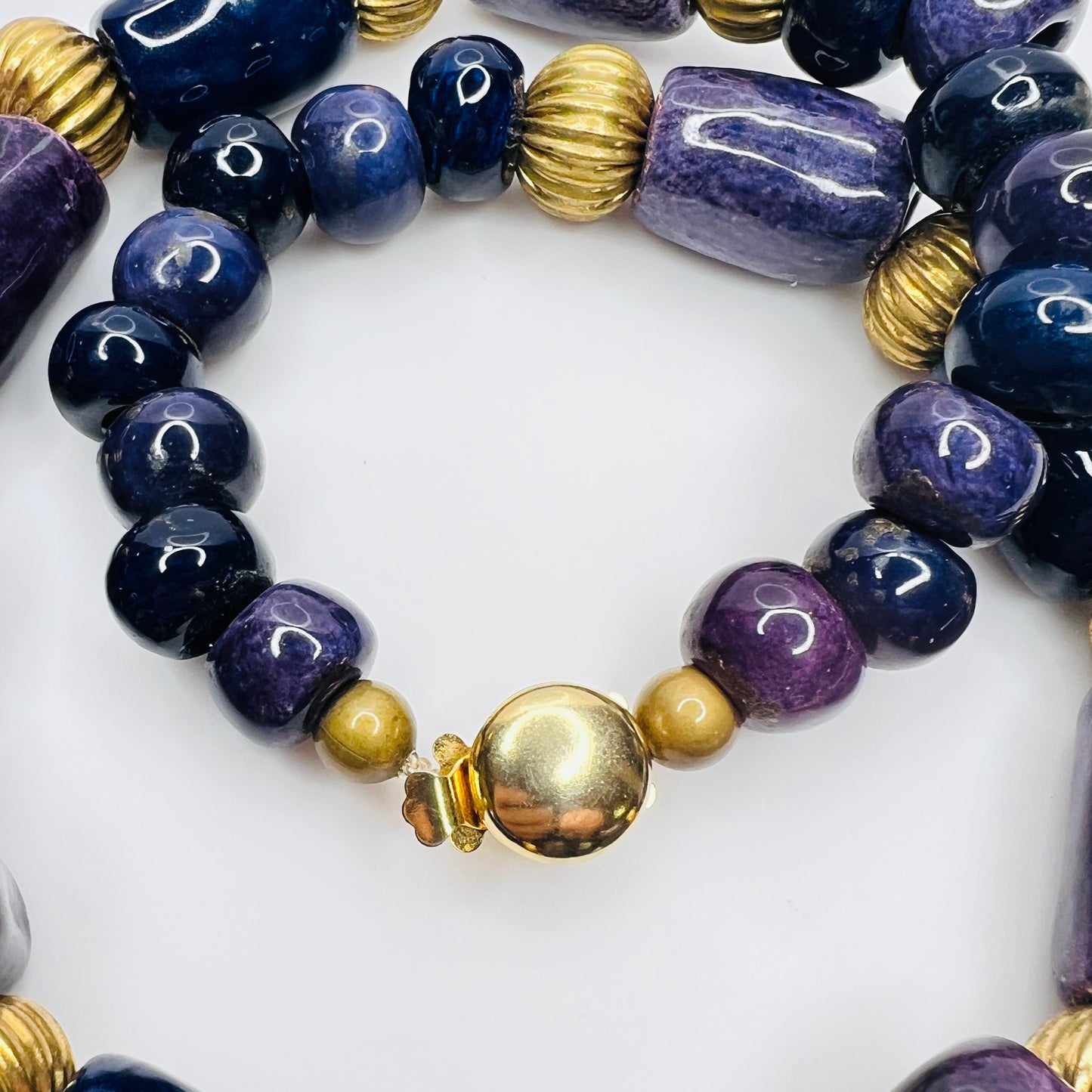 Close-up of gold tone box clasp and glossy ceramic beads, 21 inch necklace