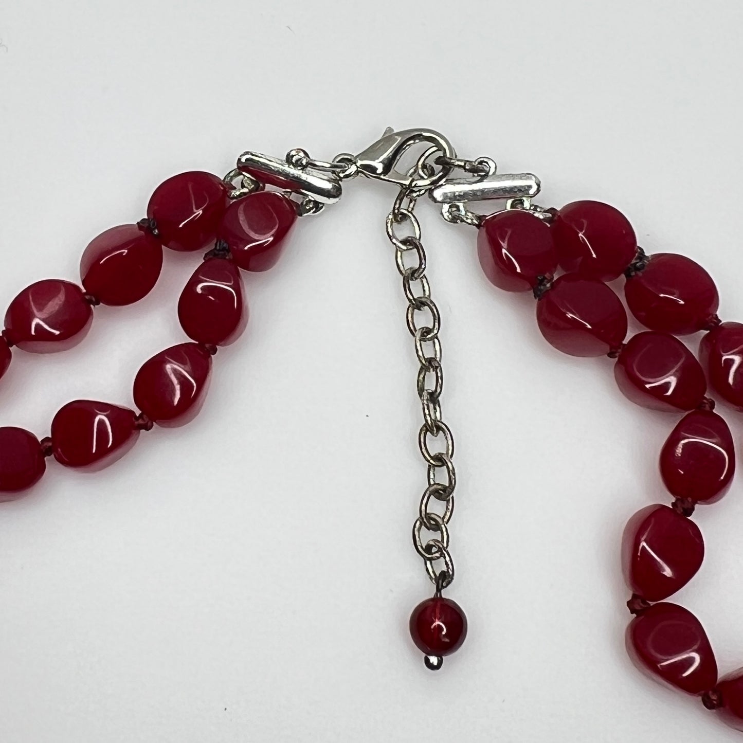 Double strand red bead necklace with large glass ovals and smaller lucite rounds with silver-tone clasp
