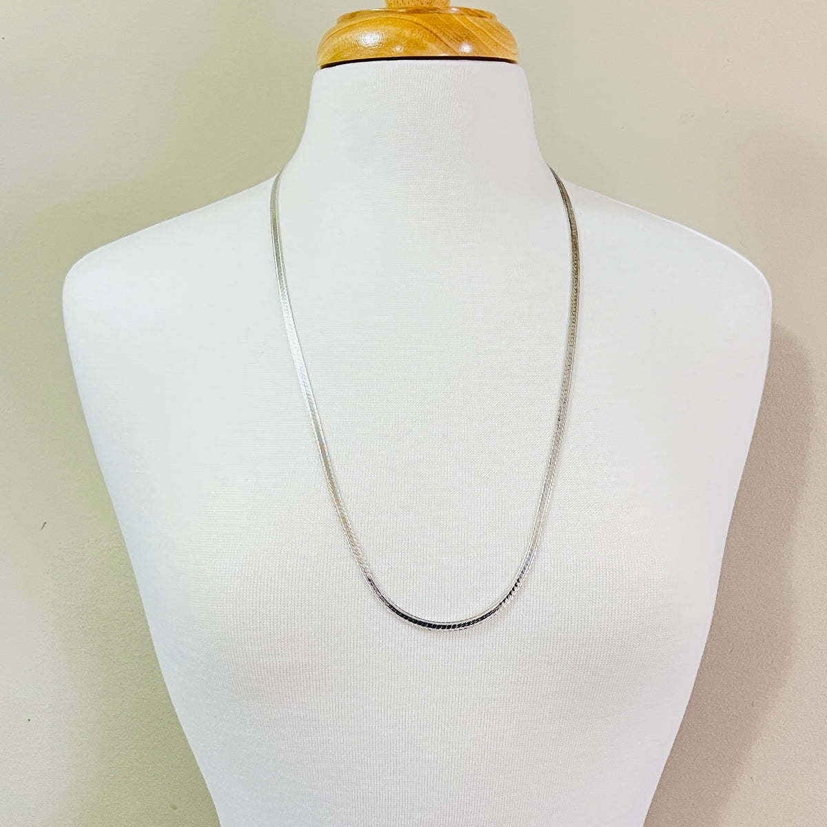 Vintage sterling silver snake chain necklace displayed on jewelry bust