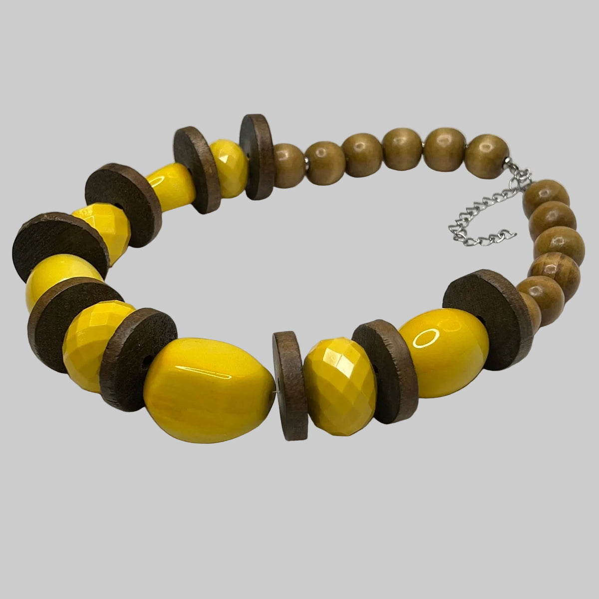 Close-up of 1" wooden disc spacers and glossy yellow lucite