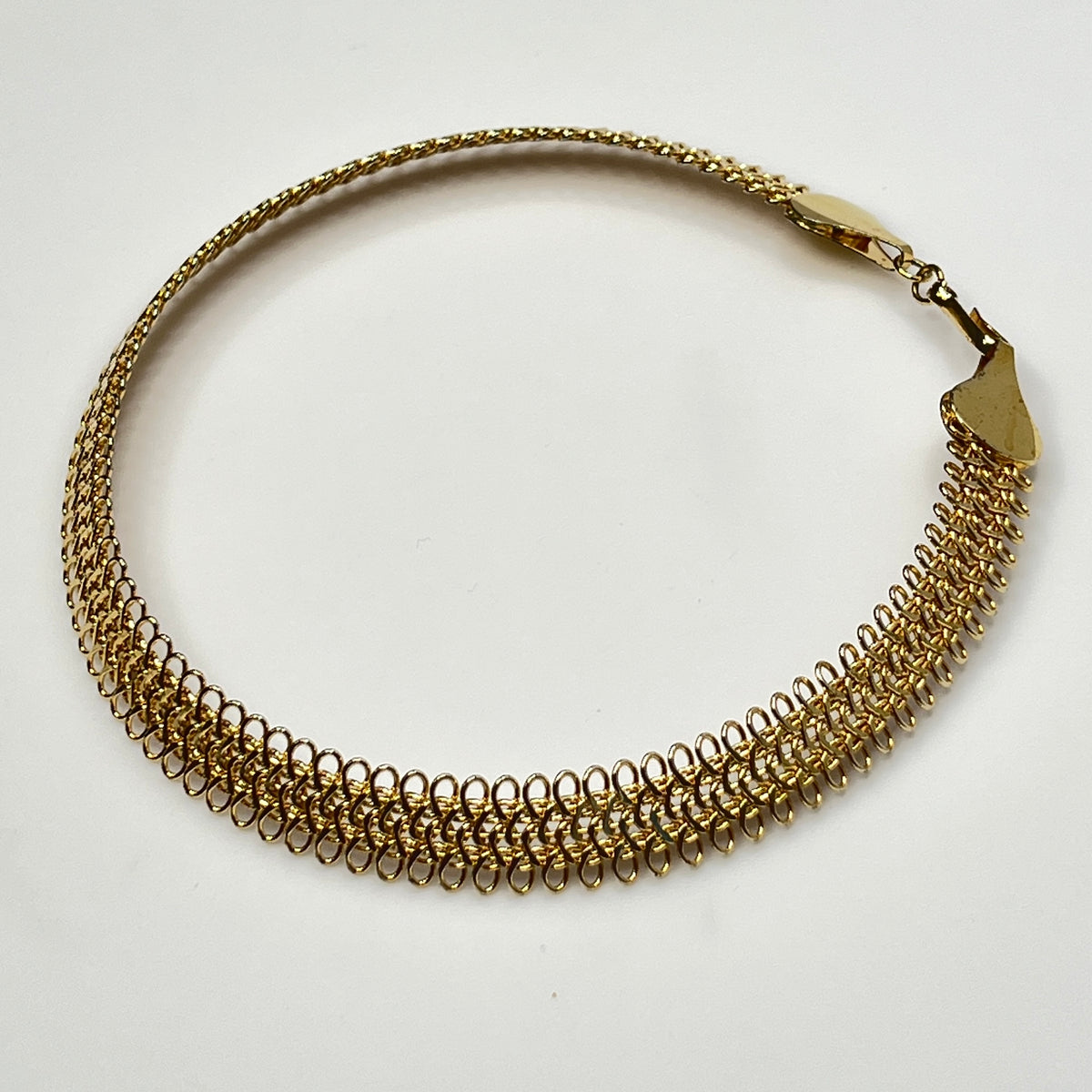 Close-up of looped gold wire choker with hook clasp
