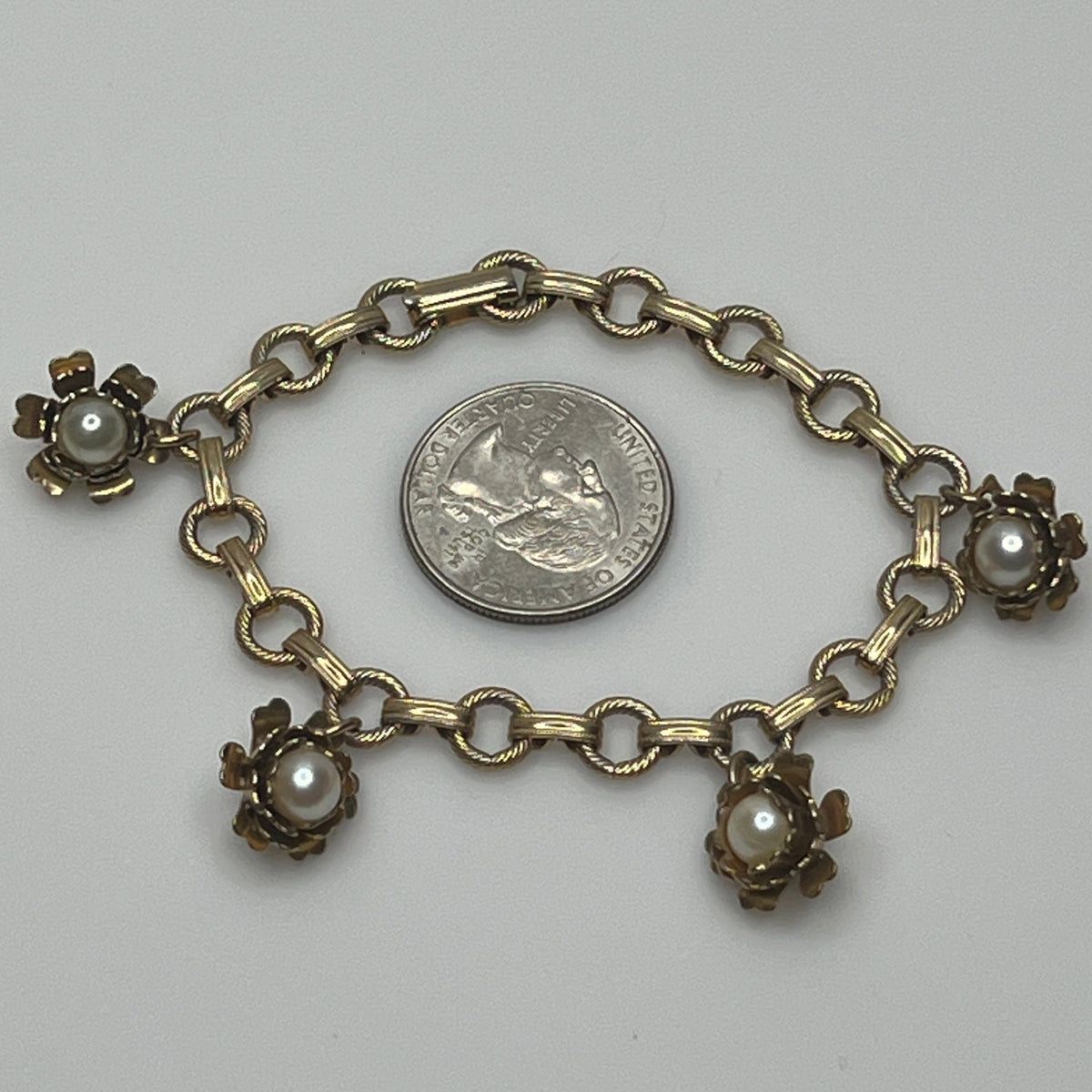 Vintage floral charm bracelet with textured links and pearl accents