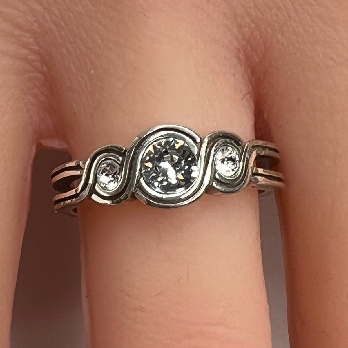 Sterling silver Brighton Infinity ring on hand with three bezel-set crystals