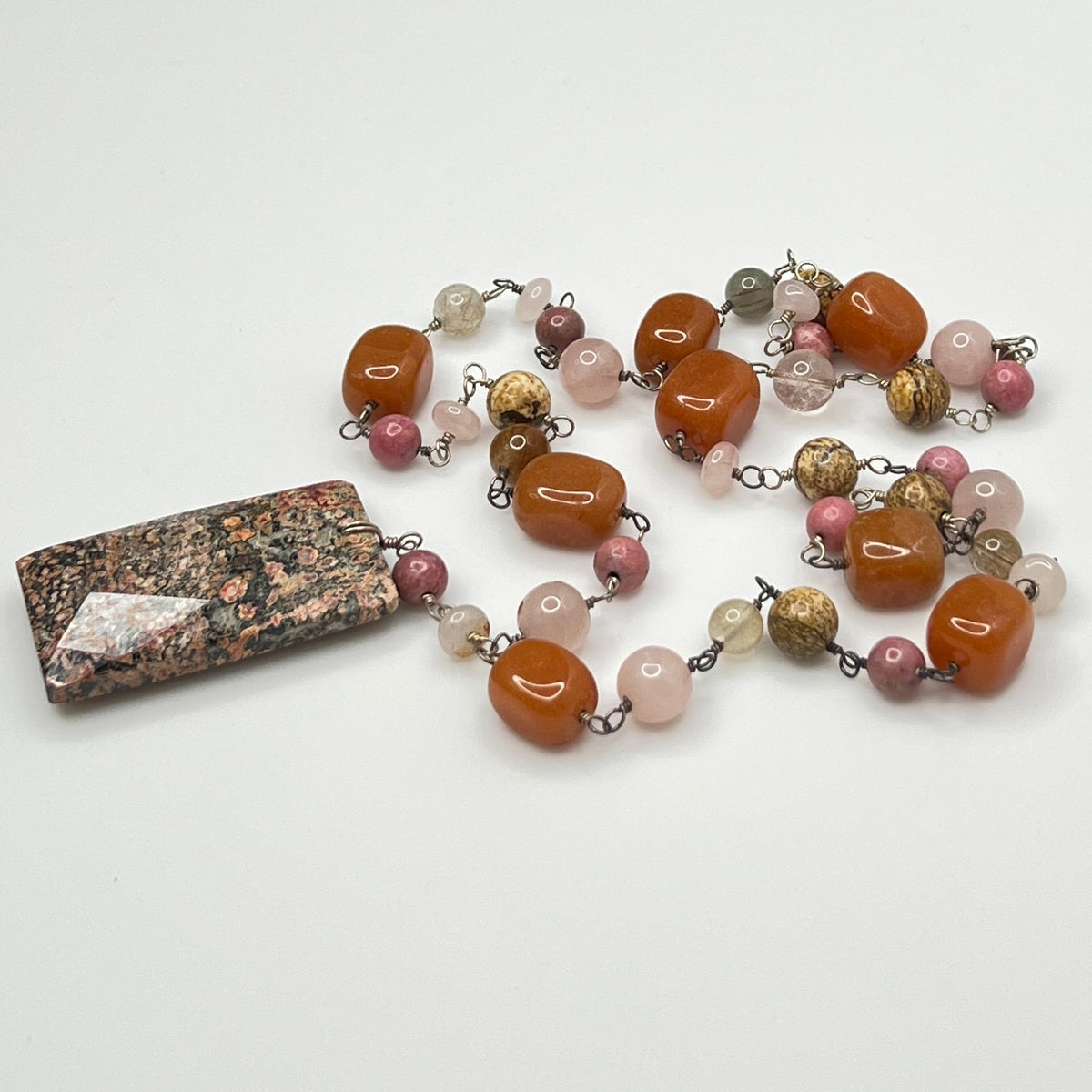 Close-up of rectangular granite pendant with mixed gemstone beads