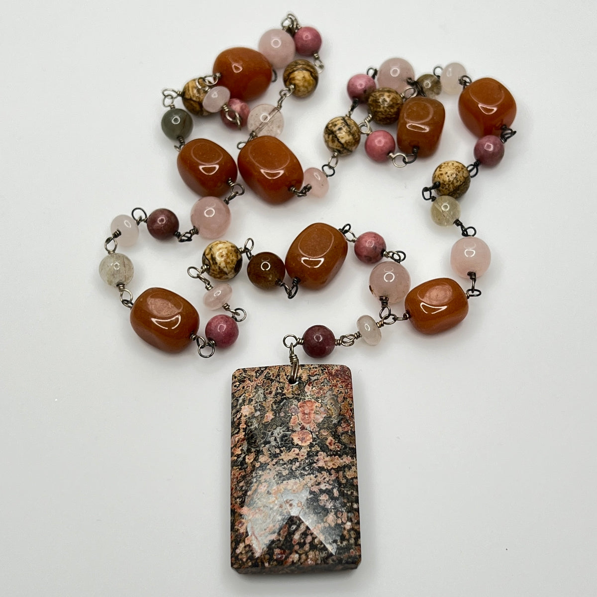 Close-up of rectangular granite pendant with mixed gemstone beads