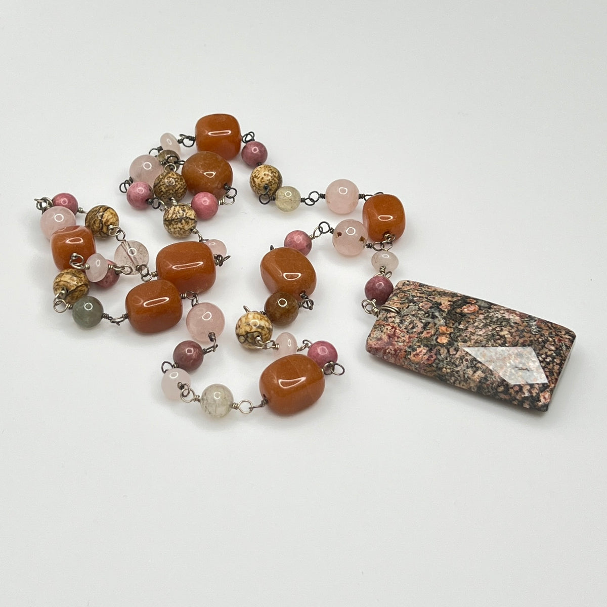 Close-up of rectangular granite pendant with mixed gemstone beads
