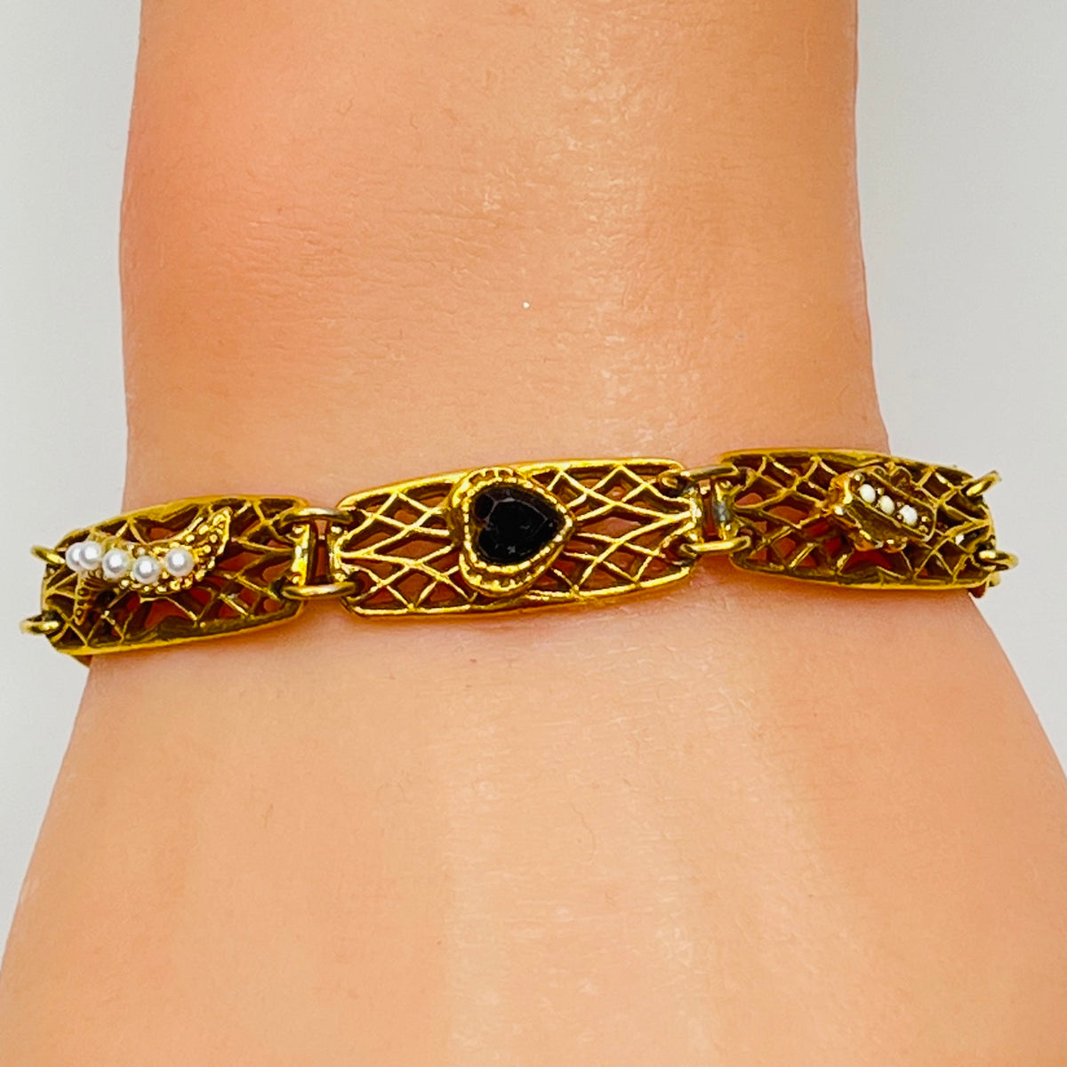 Vintage Goldette NY bracelet with filigree panels and pearl/jewel accents shown on wrist