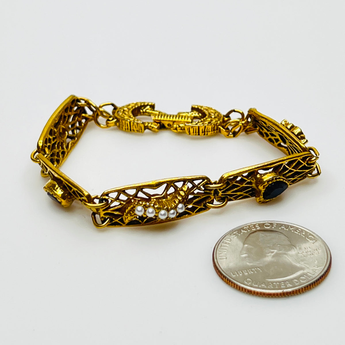 Filigree bracelet with varied gemstone details laid flat, fold-over clasp visible