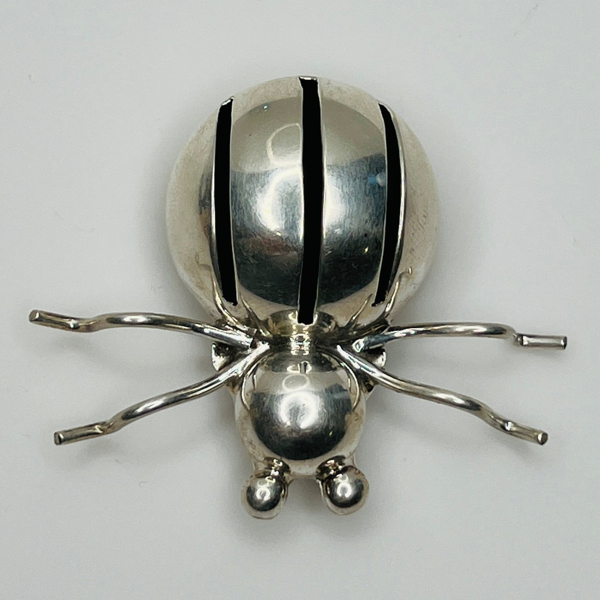 Sterling silver spider brooch with stylized body and curved legs