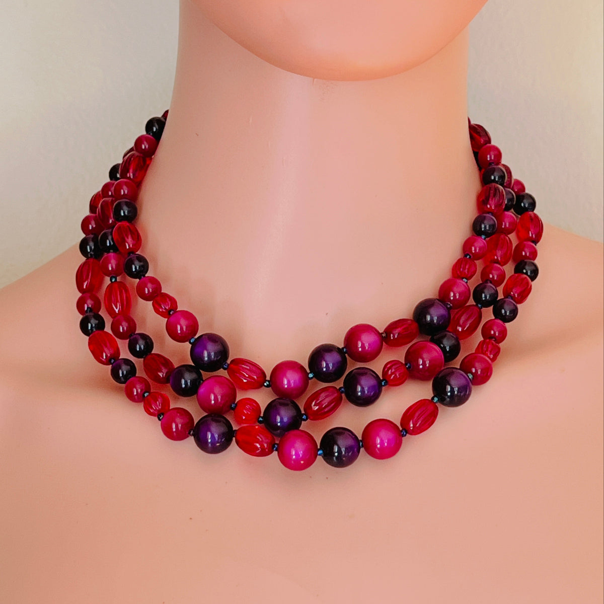 Marvella 1950s purple pink and red three strand beaded necklace displayed on mannequin.