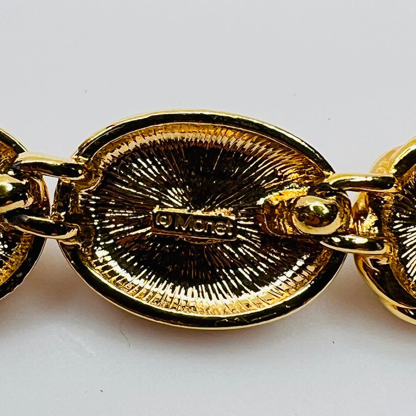 Close-up of Monet signature on back of goldtone necklace link