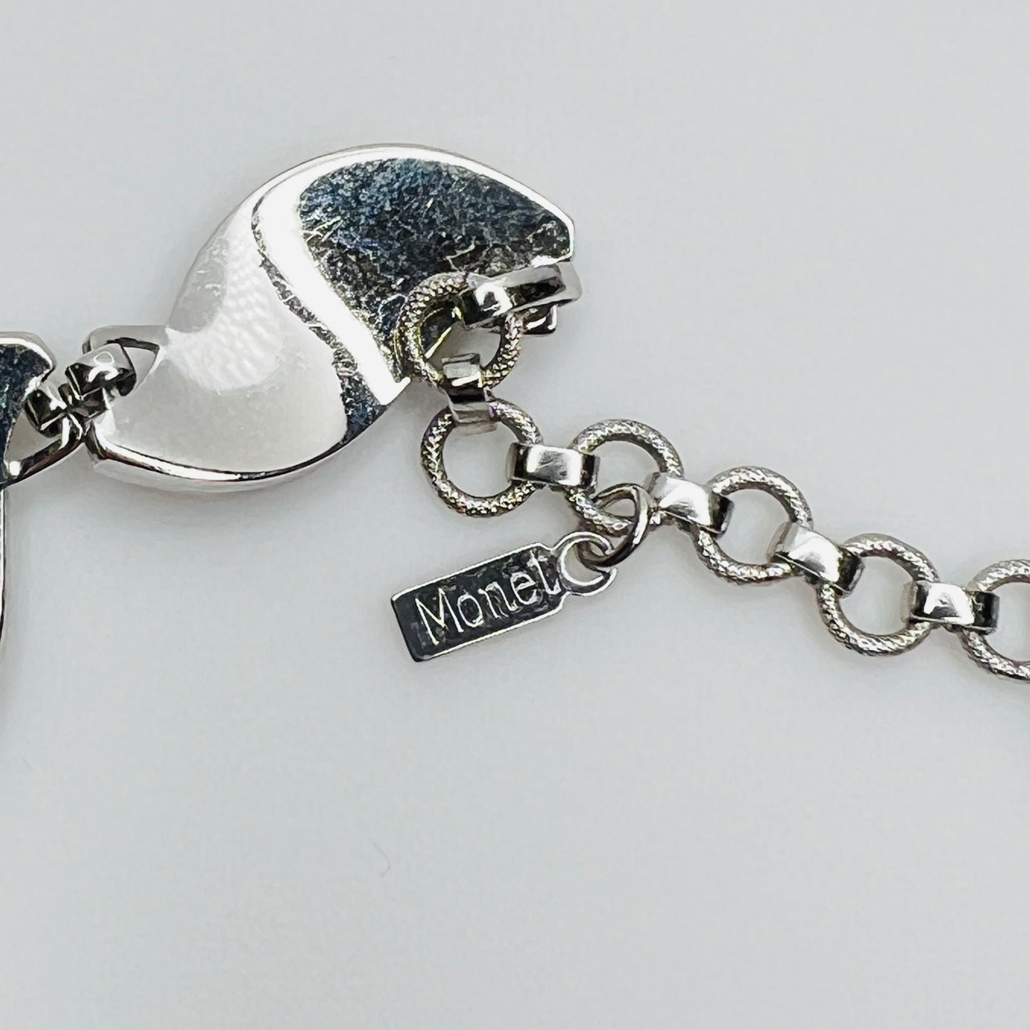 Close-up of silver Monet choker hang tag with curved leaf links
