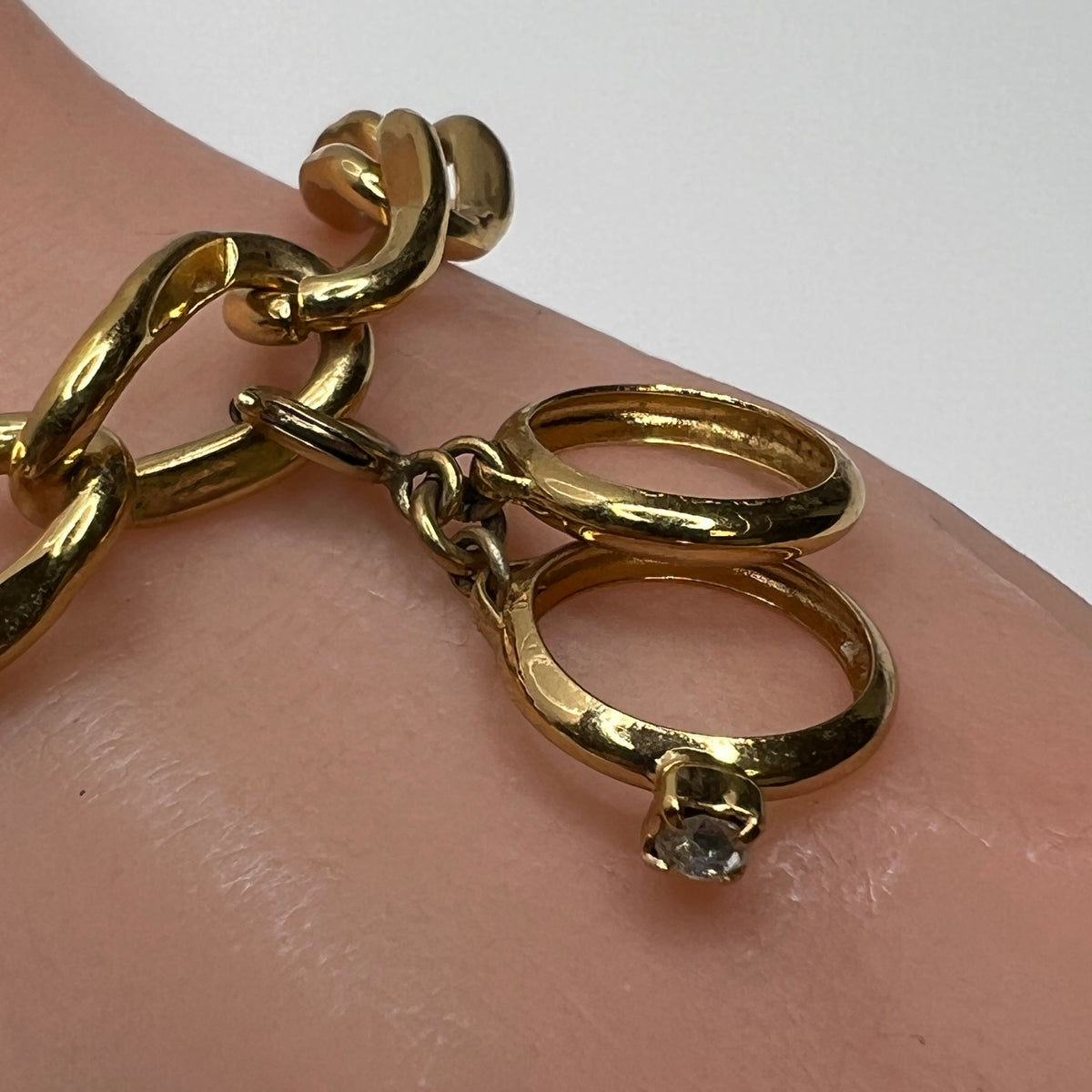 Close-up of gold wedding ring charm with rhinestone on Monet bracelet
