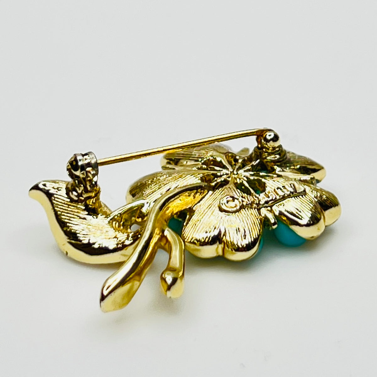 1960s floral brooch with faux turquoise cabochons and pearl center