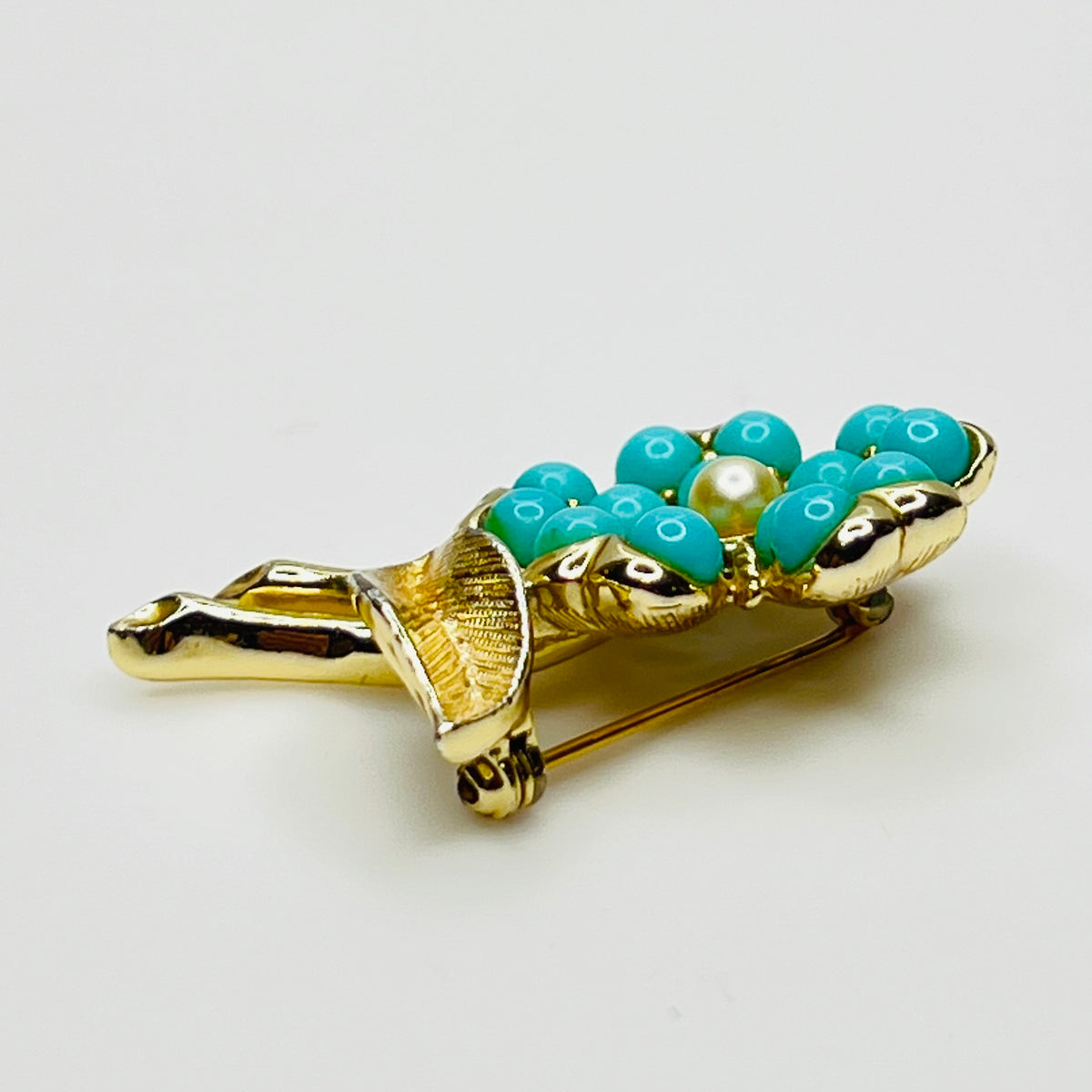 1960s floral brooch with faux turquoise cabochons and pearl center