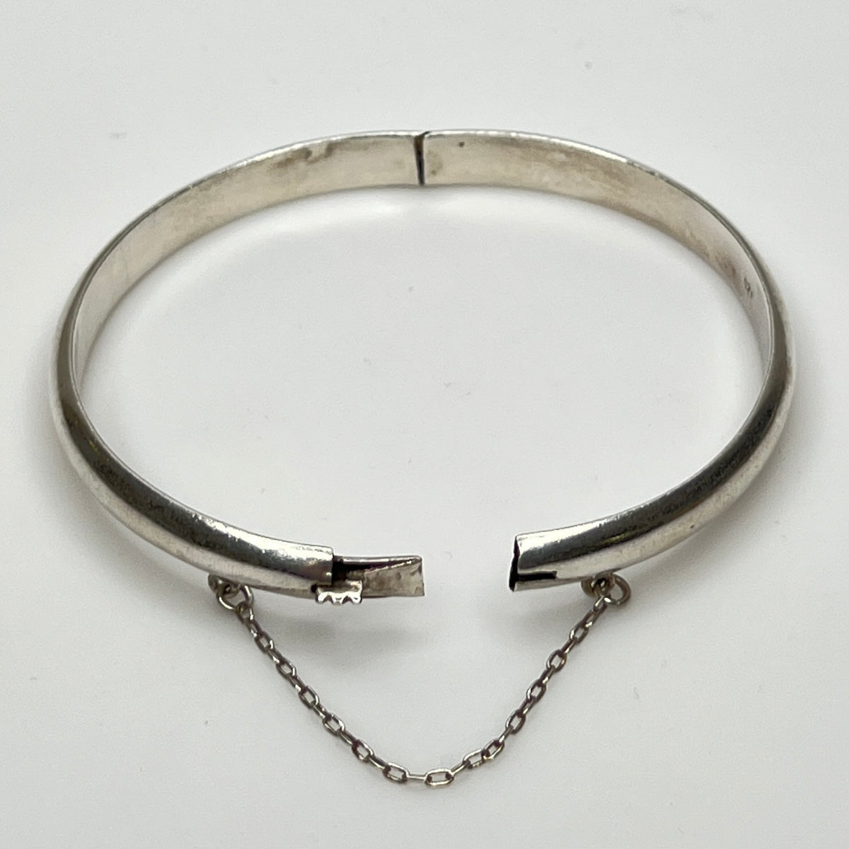 Full view of 1980s bangle with safety chain, laying flat