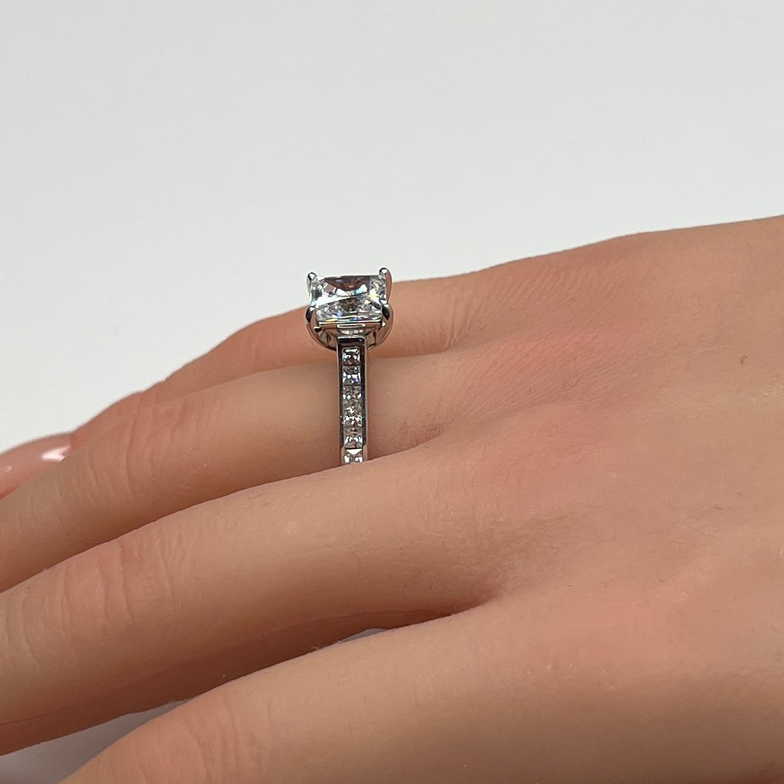 Sterling silver bridal set on model hand with princess-cut solitaire