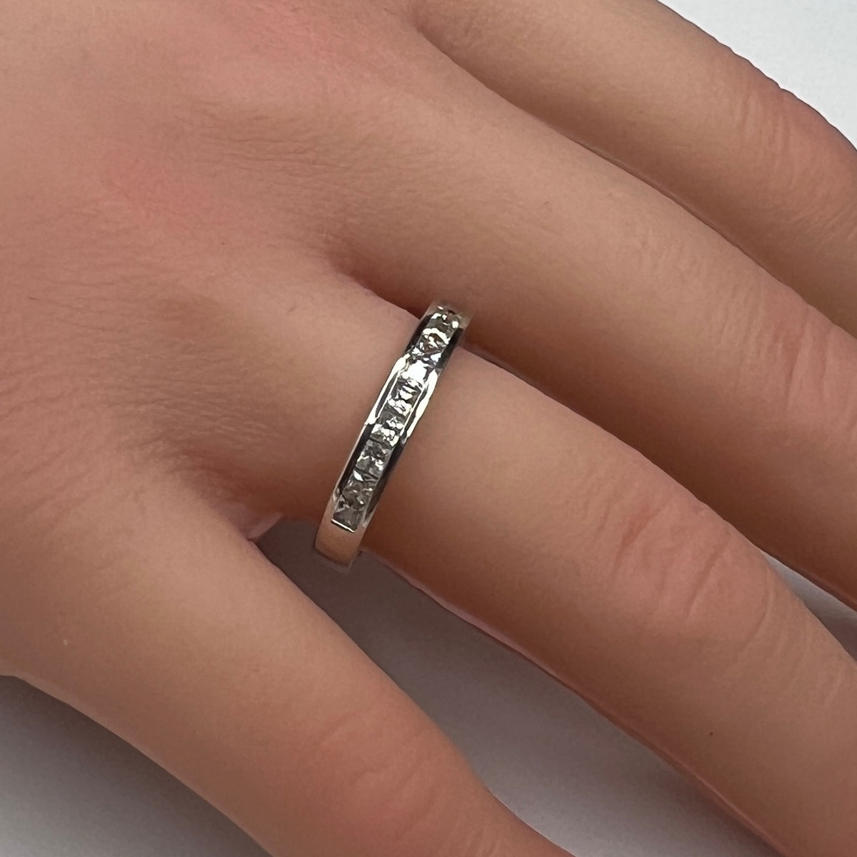 Sterling silver bridal set on model hand with princess-cut solitaire