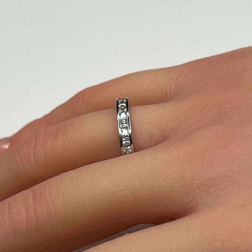 Sterling silver bridal set on model hand with princess-cut solitaire