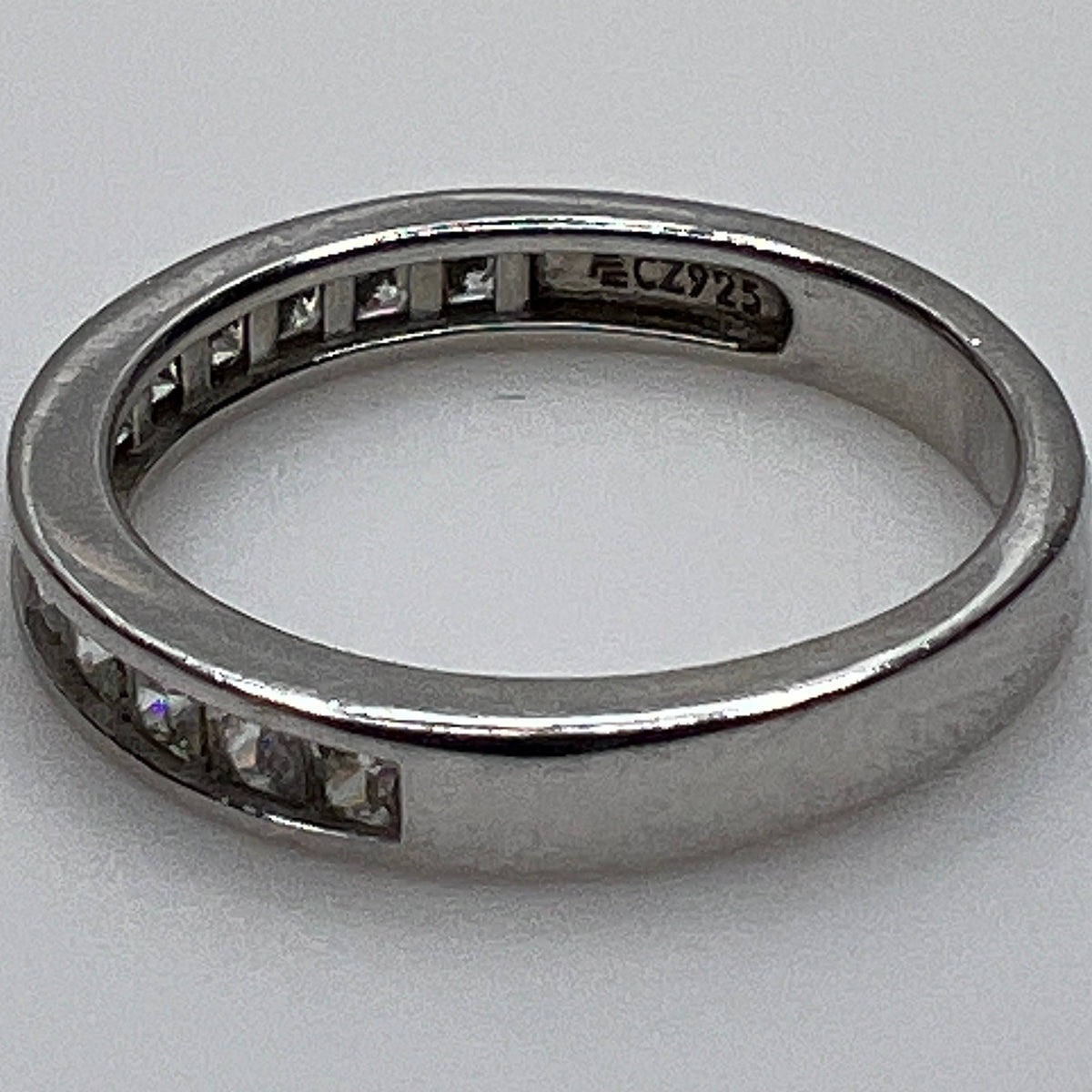 Silver ring with embedded cubic Zirconia on a light gray background