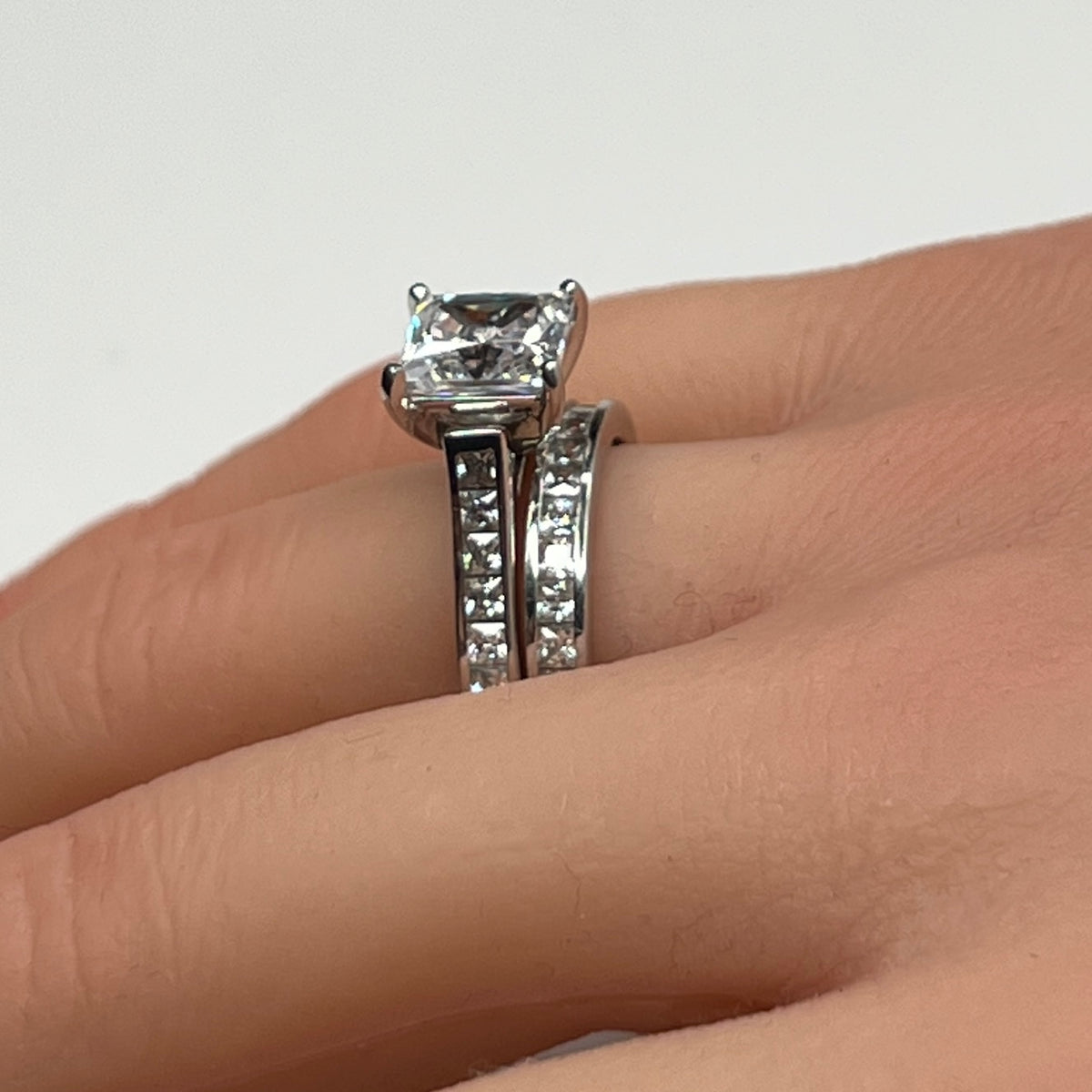 Sterling silver bridal set on model hand with princess-cut solitaire