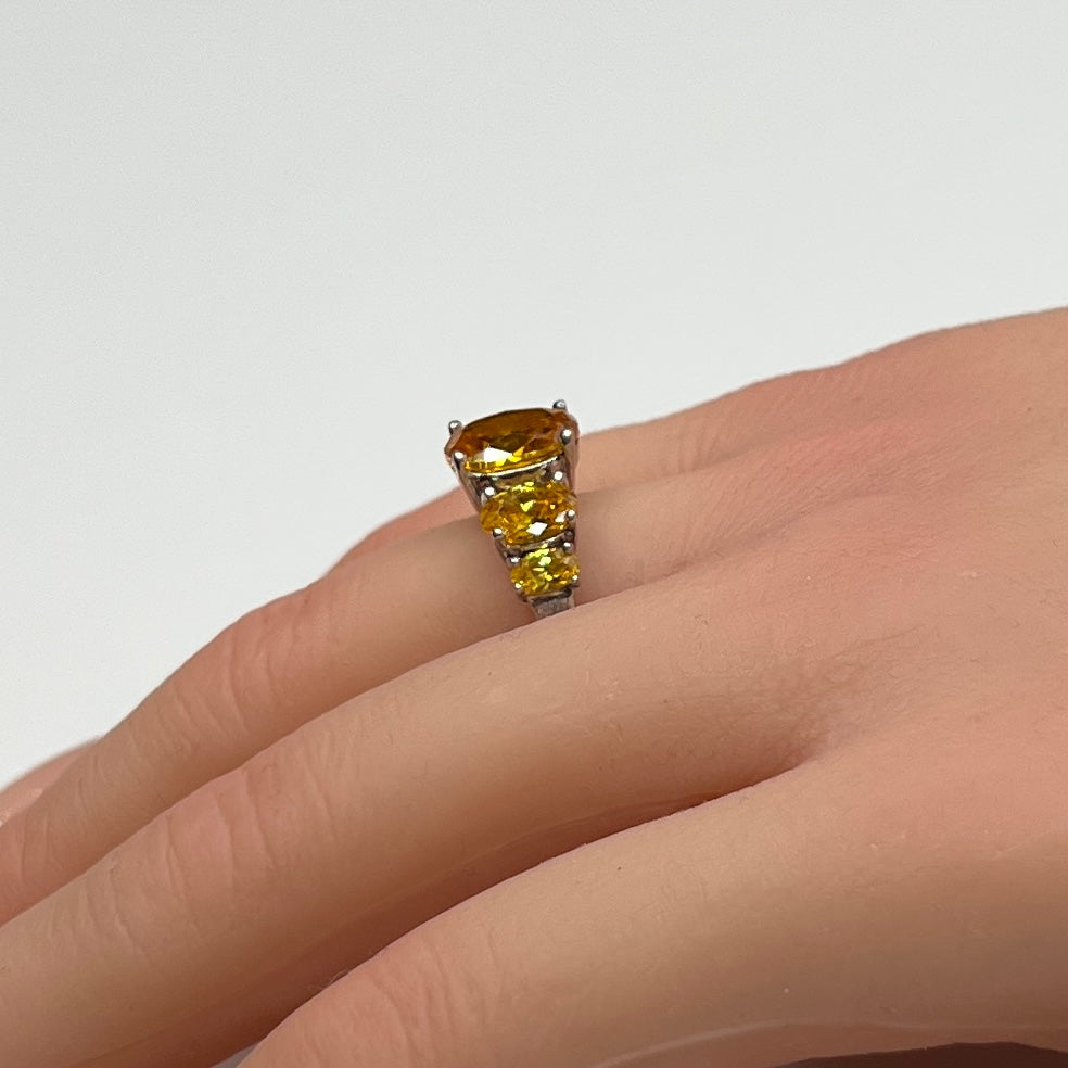 Sterling silver citrine ring worn on a hand, showing five faceted oval stones
