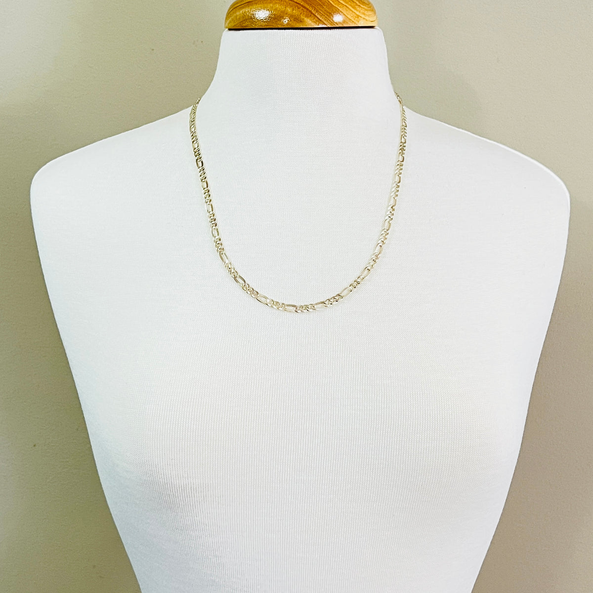 1980s vintage silver Figaro chain displayed on mannequin bust