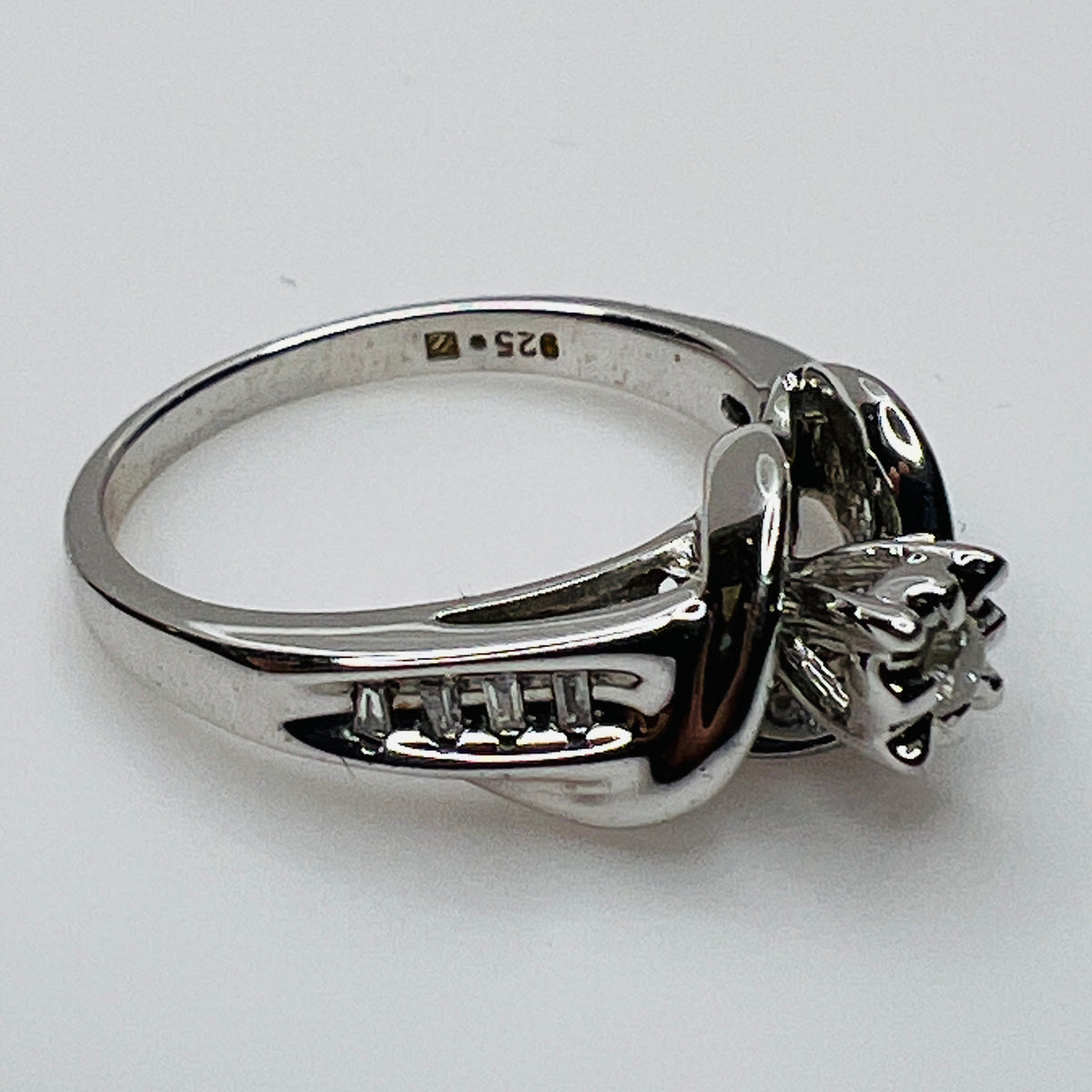 Close-up of diamond bypass ring with round and baguette stones