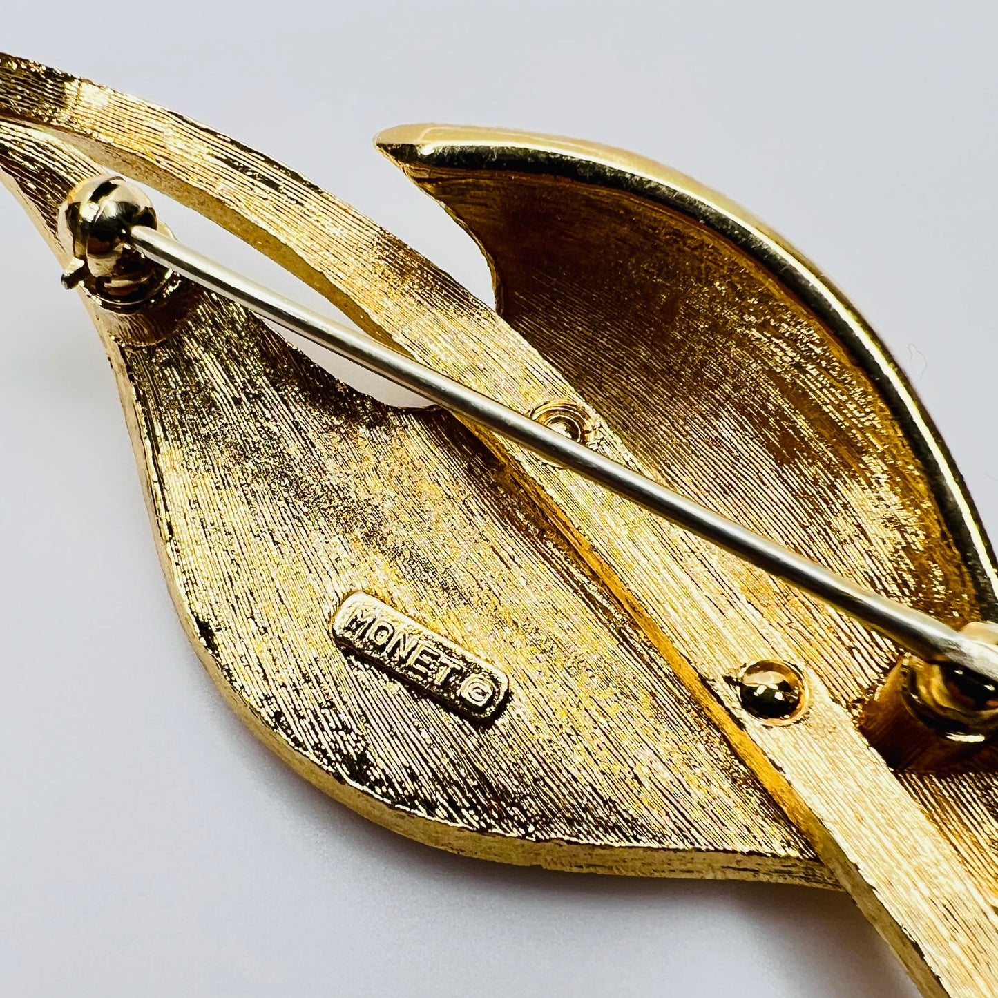 Close-up of Monet signature on brooch back