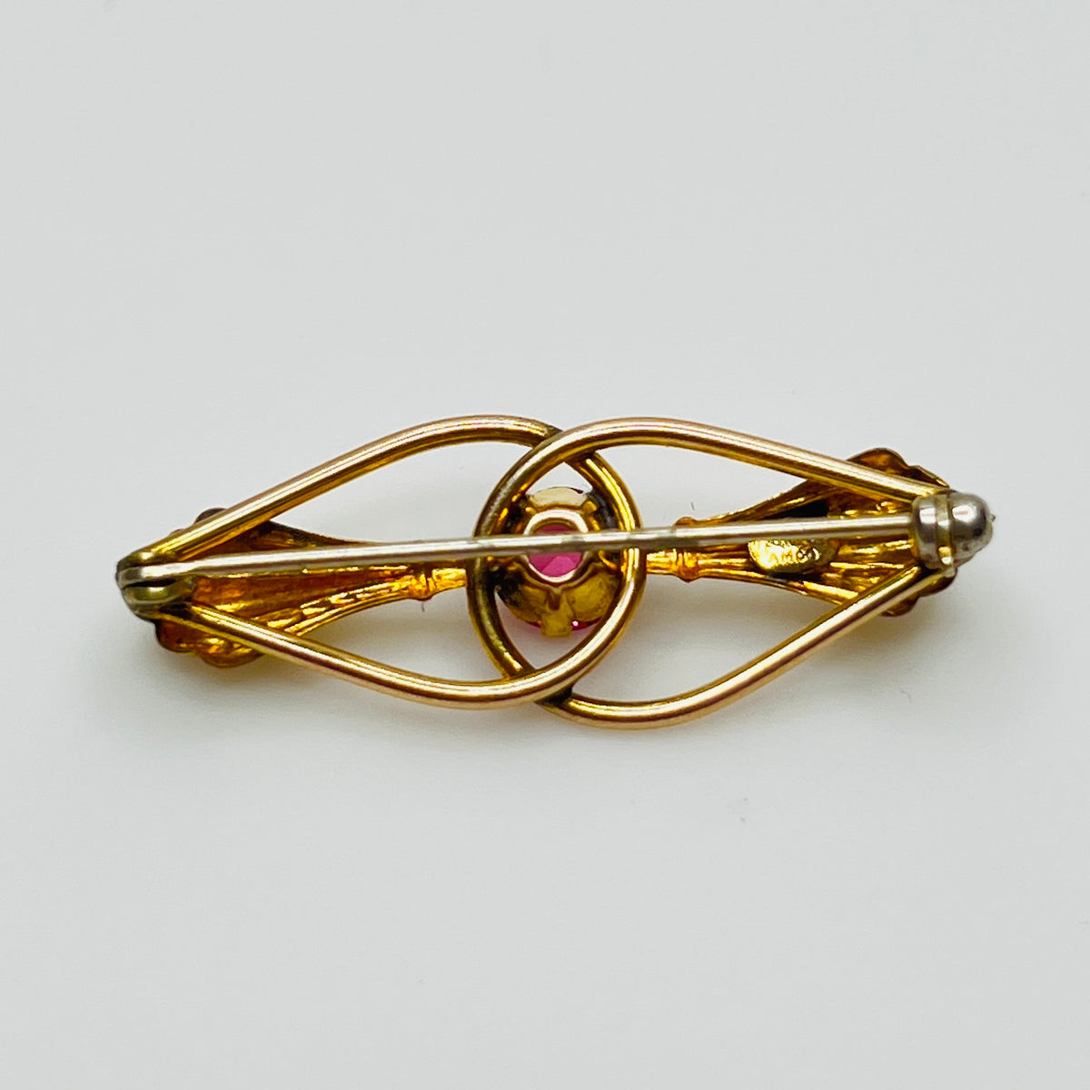 Close-up of signed AMCO bar pin with botanical styling in gold-tone