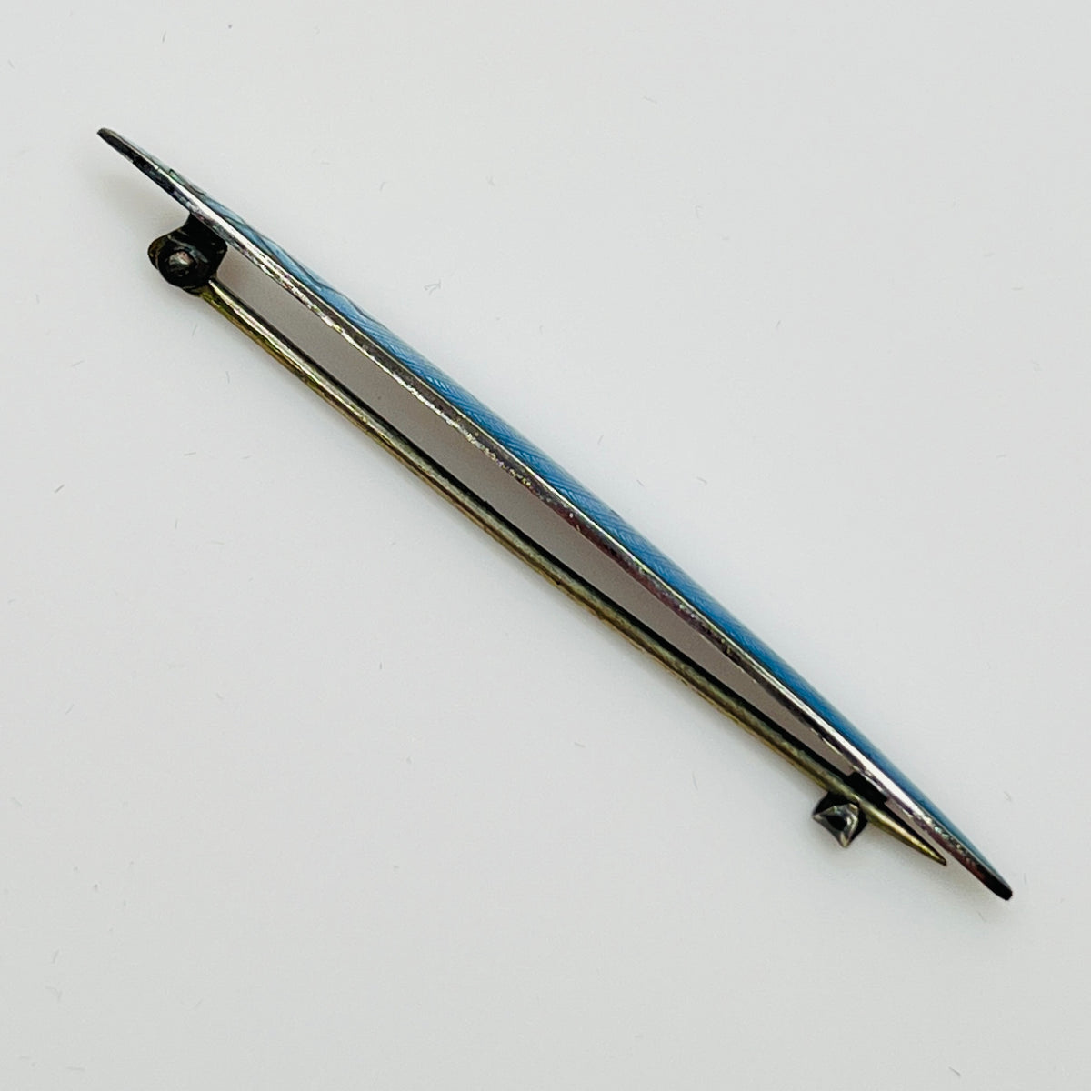 Side view of brooch showing silver base and clasp