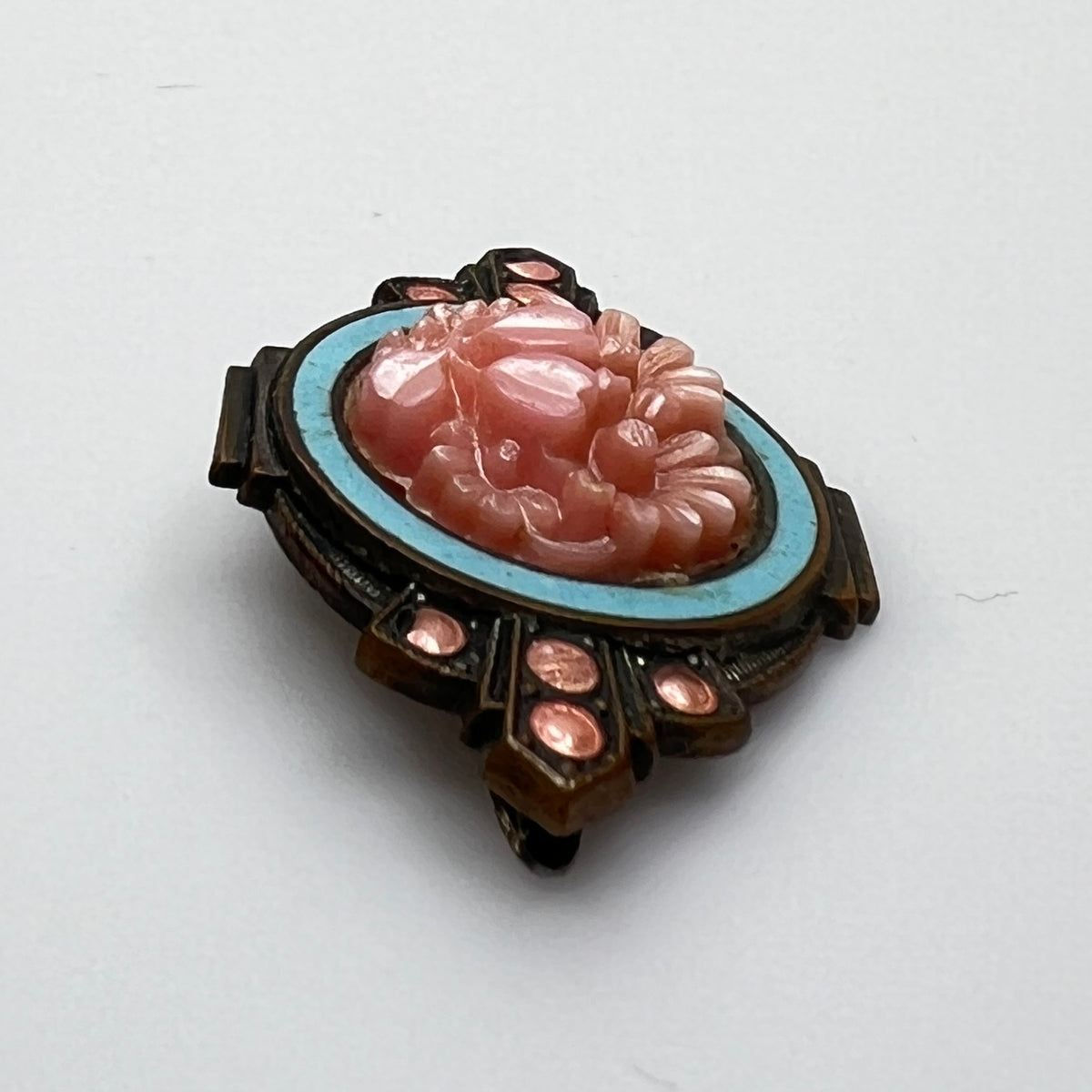 Side profile of Victorian enamel brooch with molded floral centerpiece