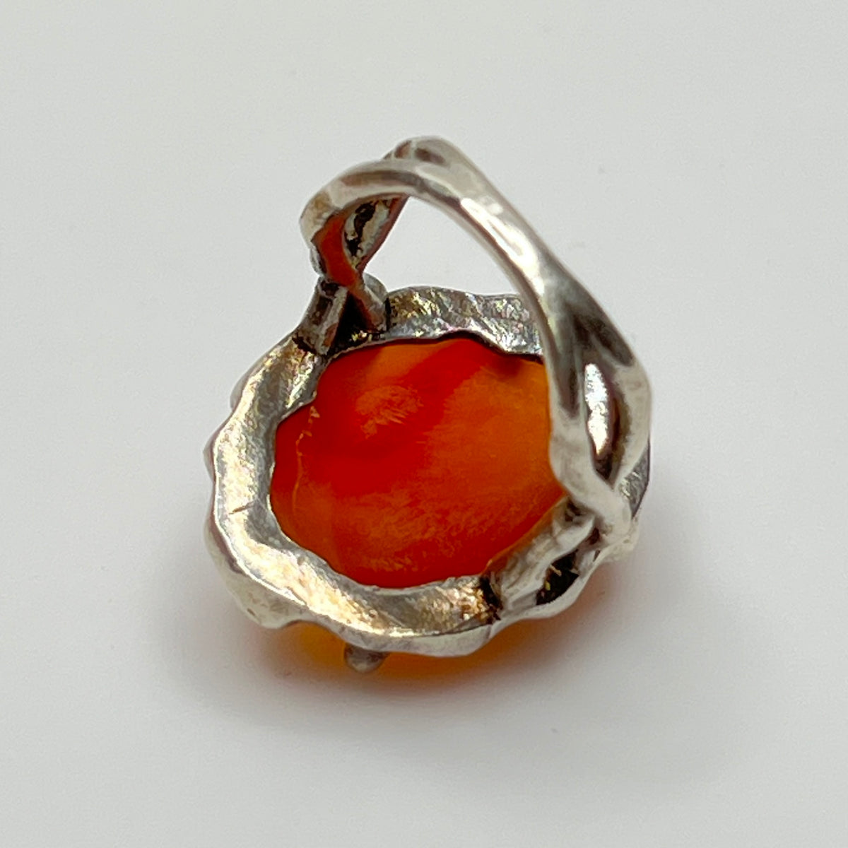 Vintage sterling silver ring with faceted oval orange carnelian in sculptural bezel setting