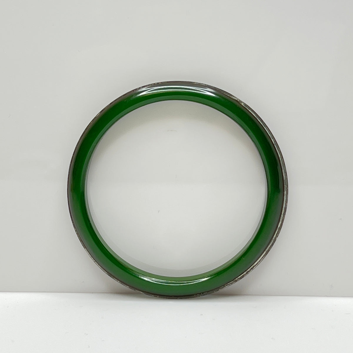 Deep green Bakelite bangle bracelet with metal insert, side view