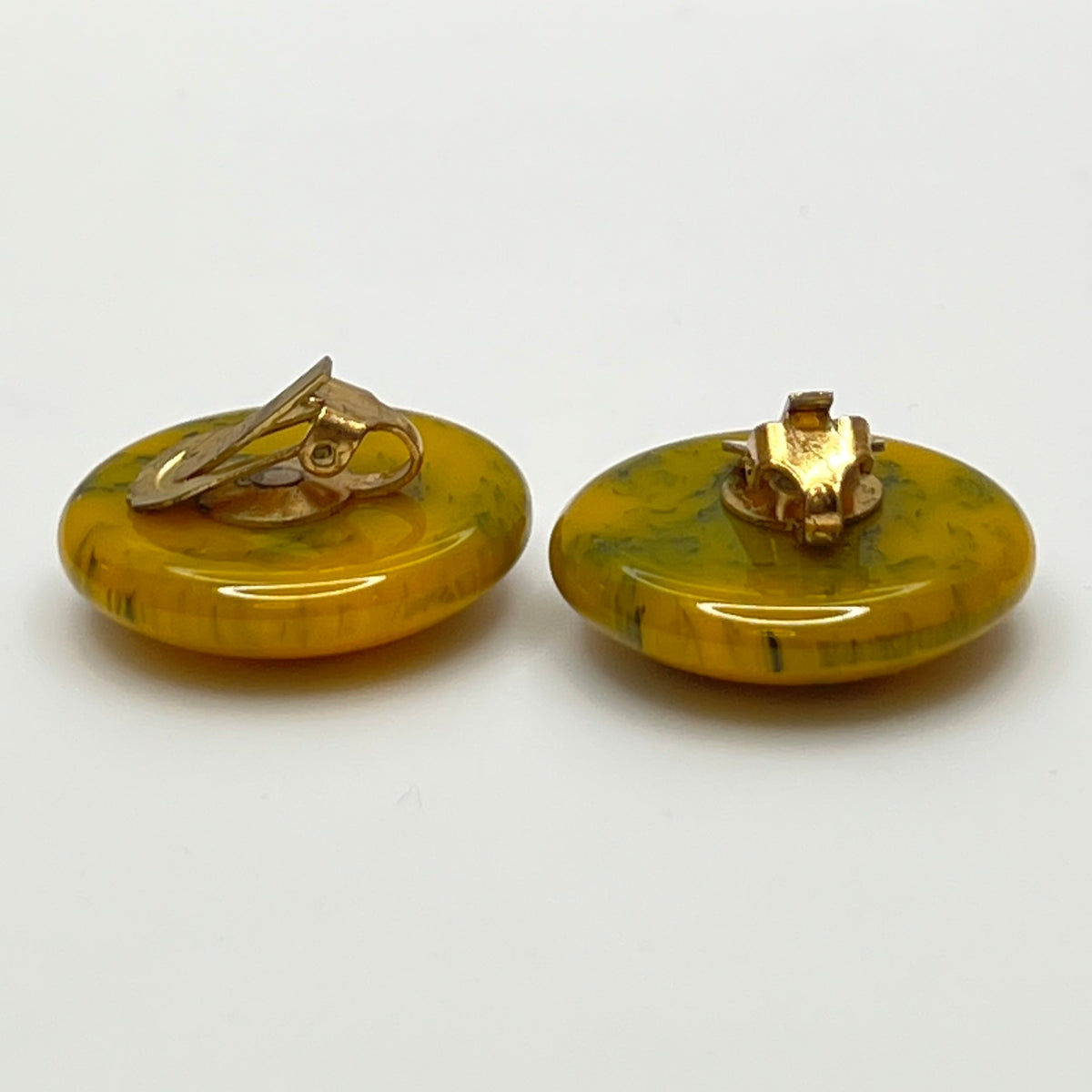 Pair of round marbled yellow and black Bakelite clip-on earrings